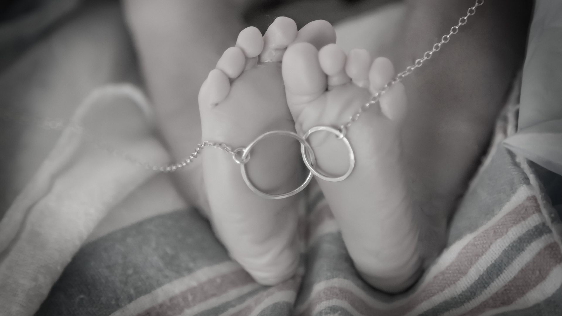 A child's feet with a necklace around them. 