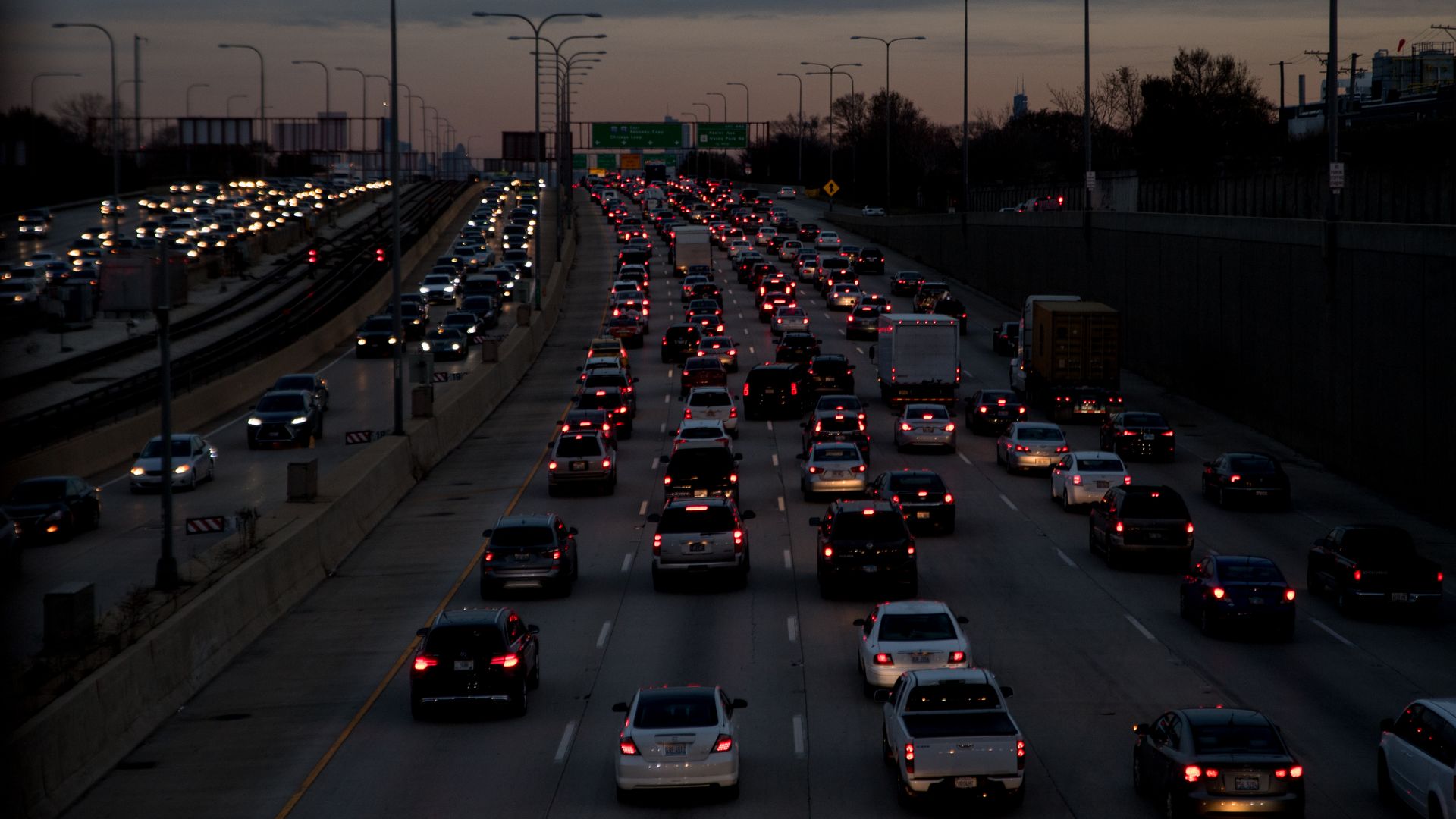 Masses of vehicles move slowly on the Montrose Ave overpass in Chicago at dusk