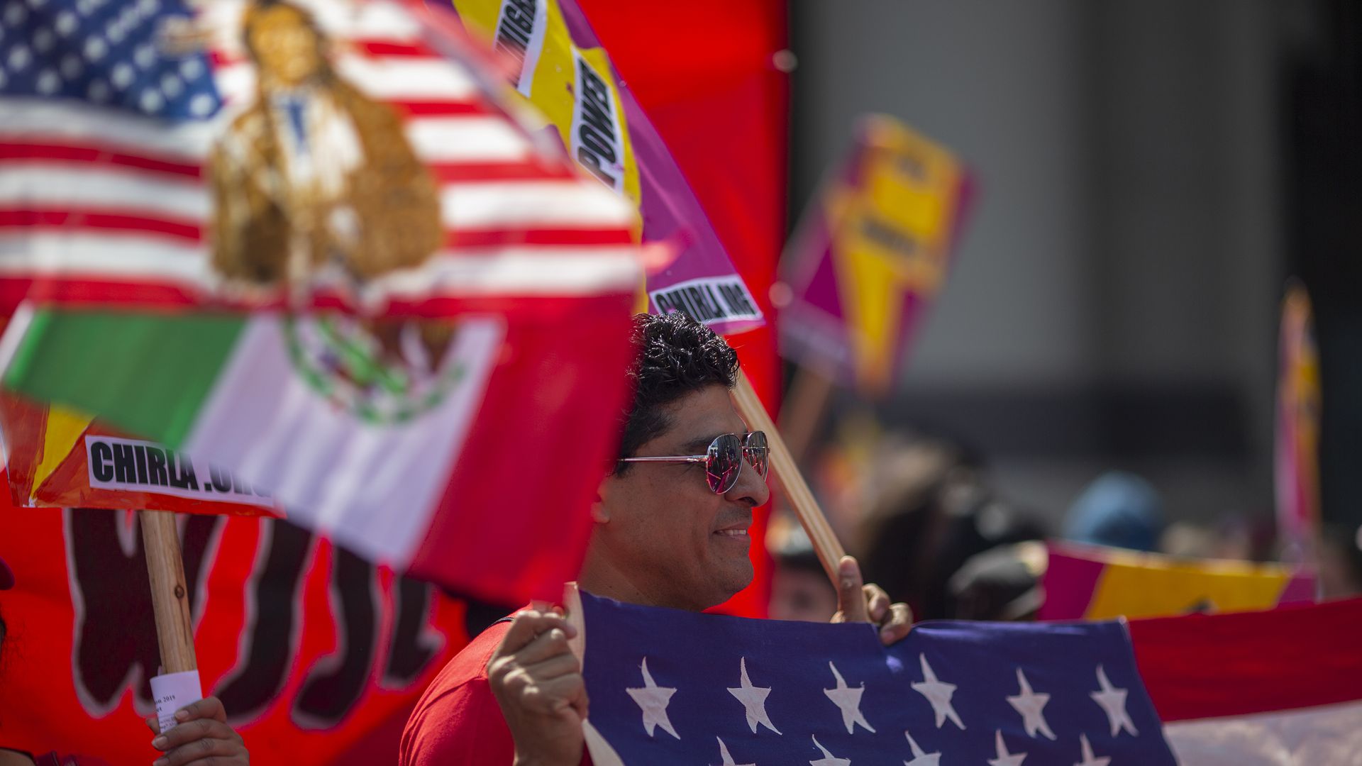 A man holds an American flag during a march on May Day, in Los Angeles, California.