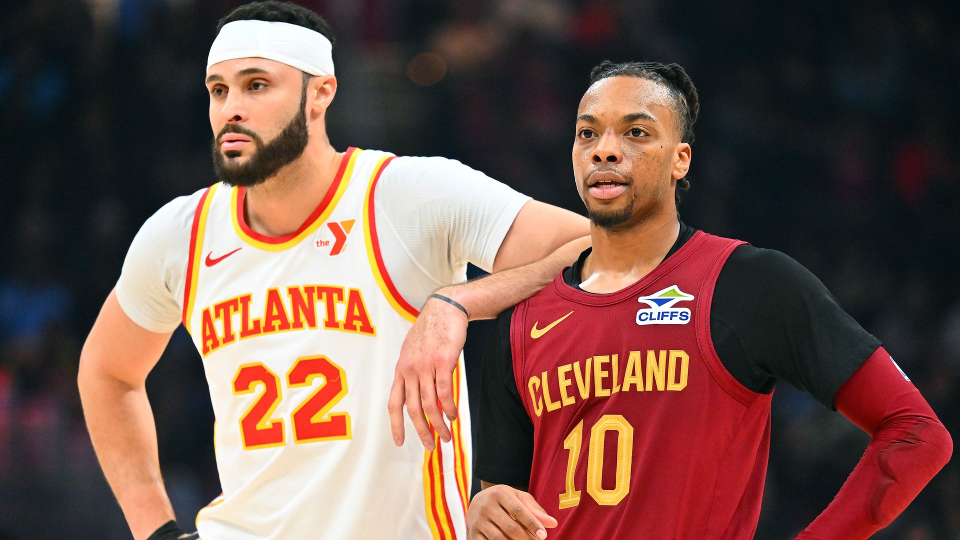 Larry Nance Jr. in white Hawks jersey with arm on shoulder of Darius Garland in red Cavs jersey