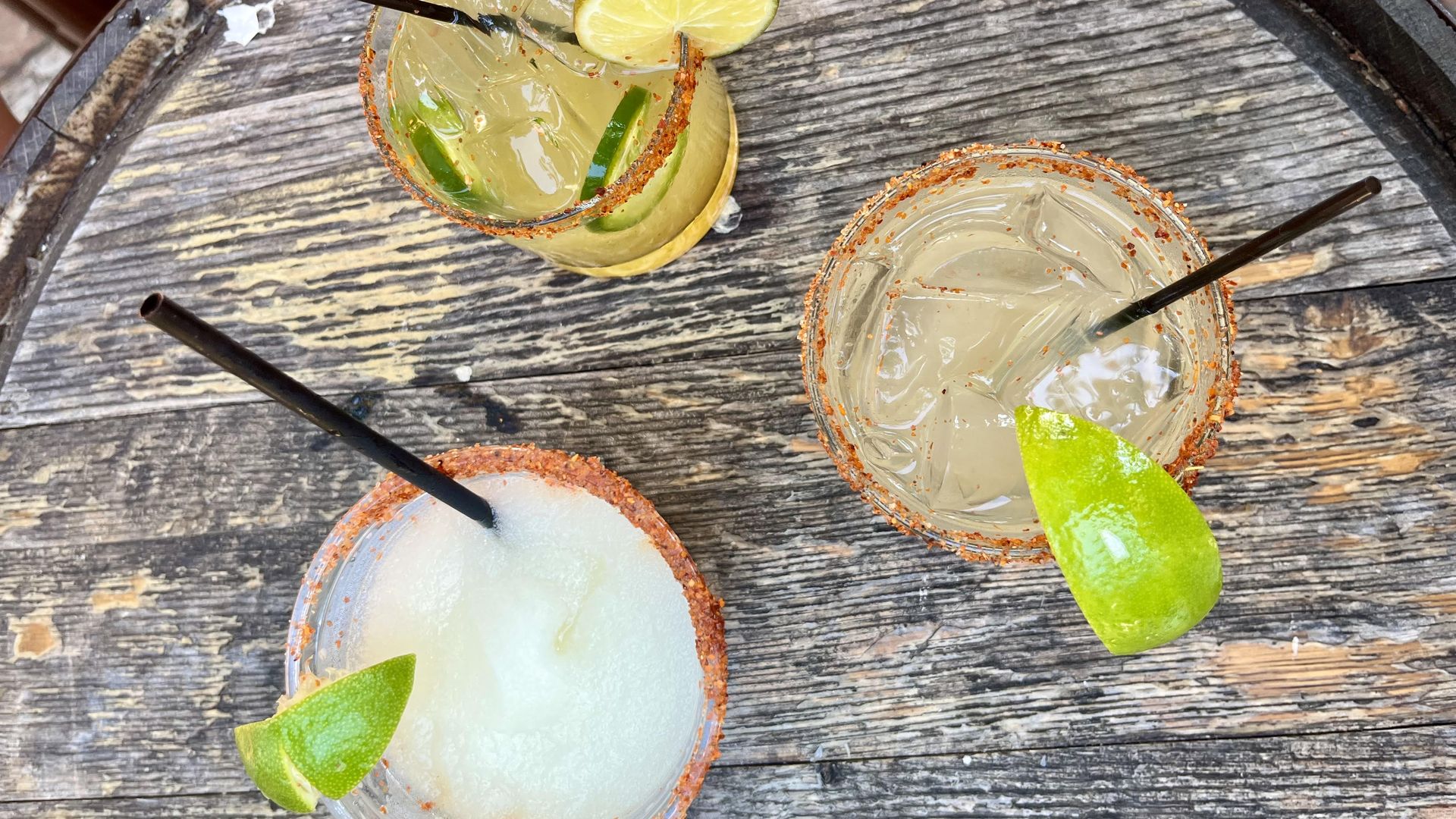 Three margaritas on a wooden barrel: One frozen, one on the rocks and one spicy.