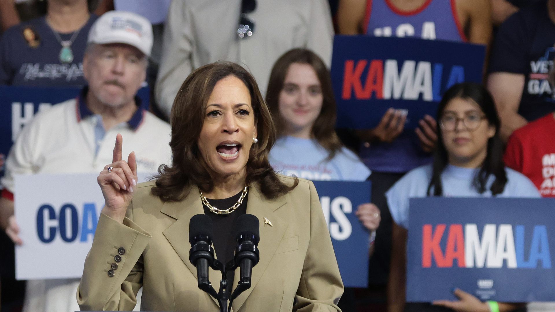 Harris speaks at a campaign rally wearing a beige blazer 