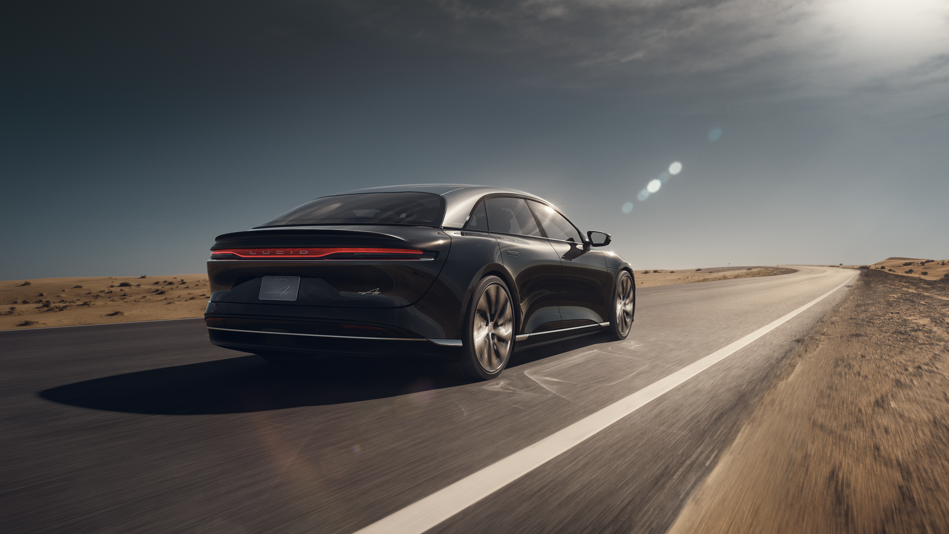 Beauty image of a Lucid Air electric sedan on a deserted highway, from Lucid Motors