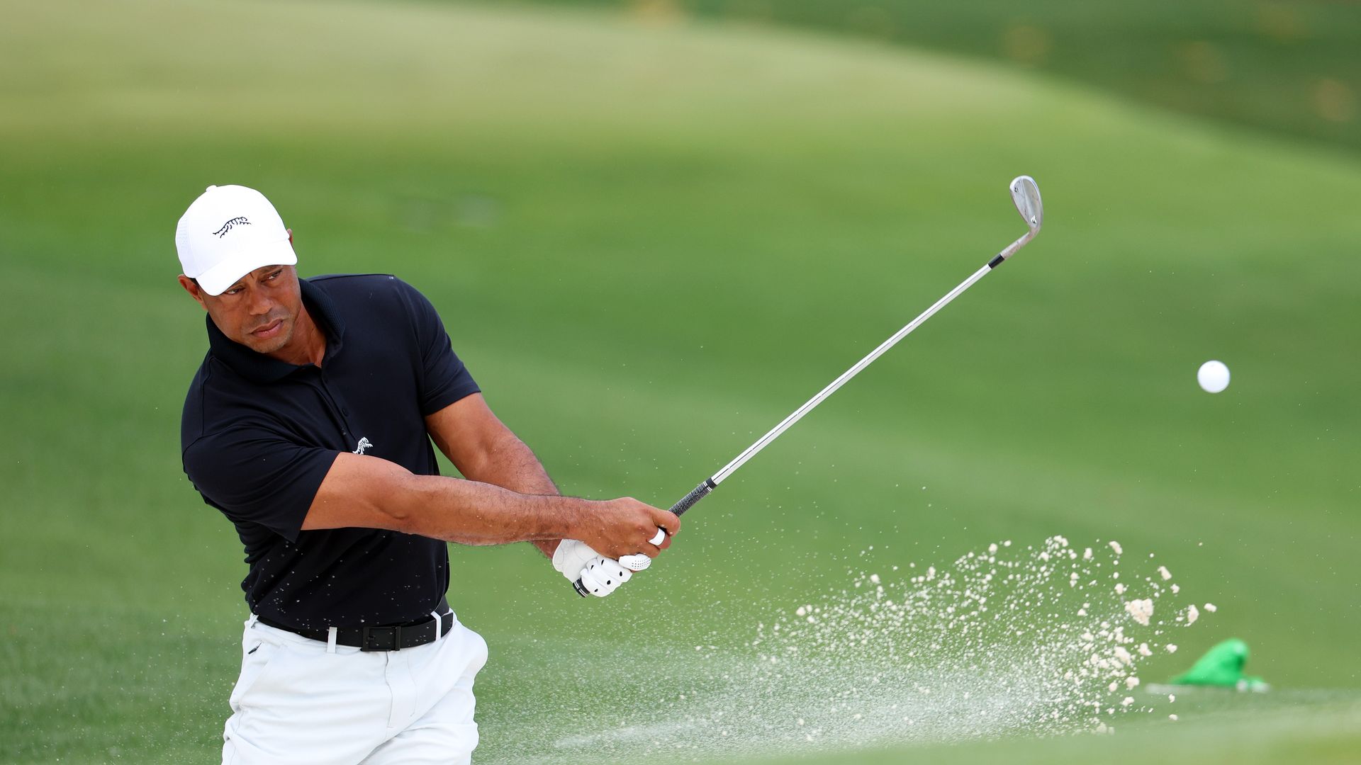 AUGUSTA, GEORGIA - APRIL 10: Tiger Woods of the United States takes a shot from the practice bunker during a practice round prior to the 2024 Masters Tournament at Augusta National Golf Club on April 10, 2024 in Augusta, Georgia. (Photo by Andrew Redington/Getty Images)