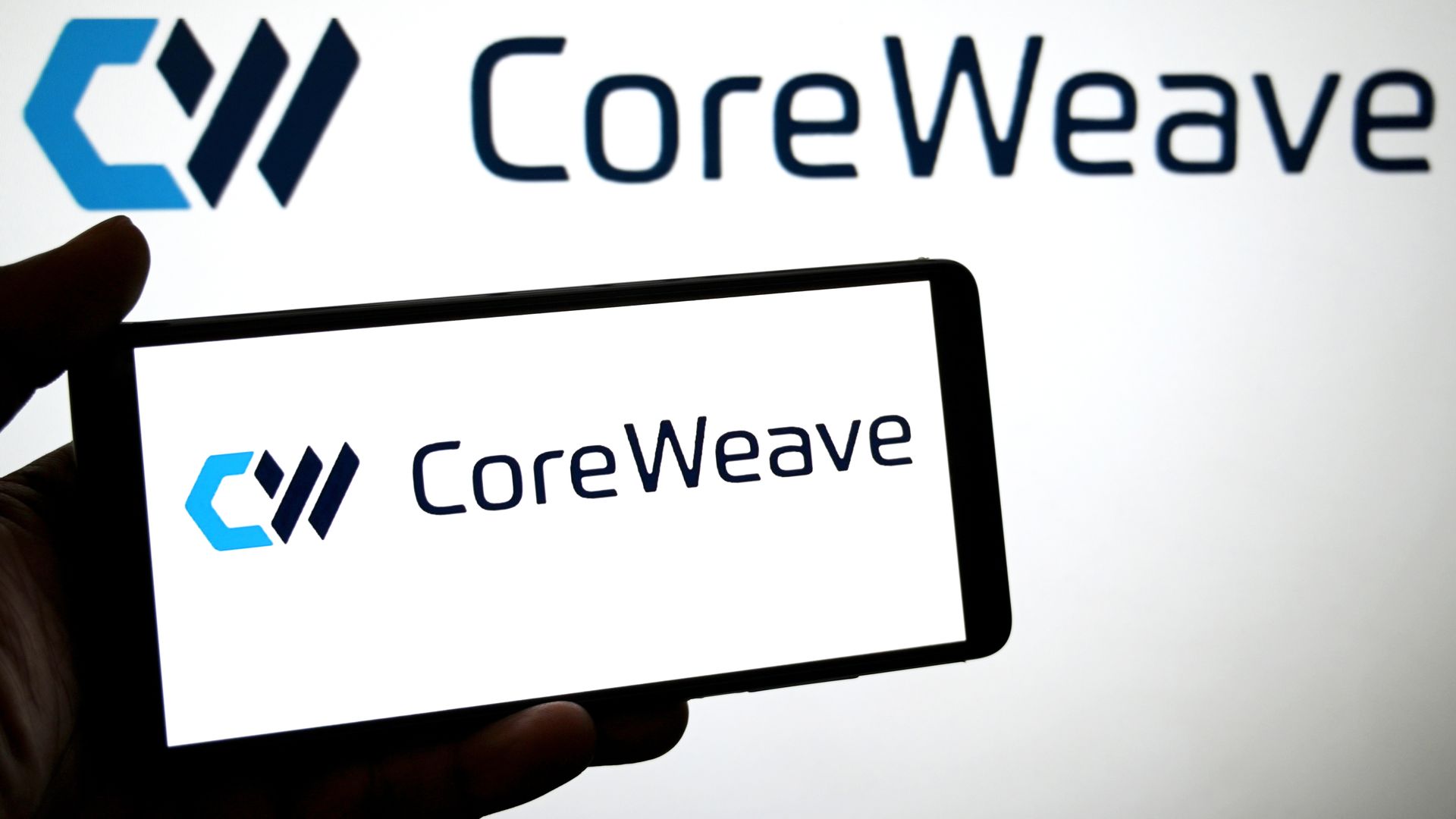 INDIA - 2025/06/09: In this photo illustration, a CoreWeave logo is seen displayed on a smartphone and in the background. (Photo Illustration by Avishek Das/SOPA Images/LightRocket via Getty Images)