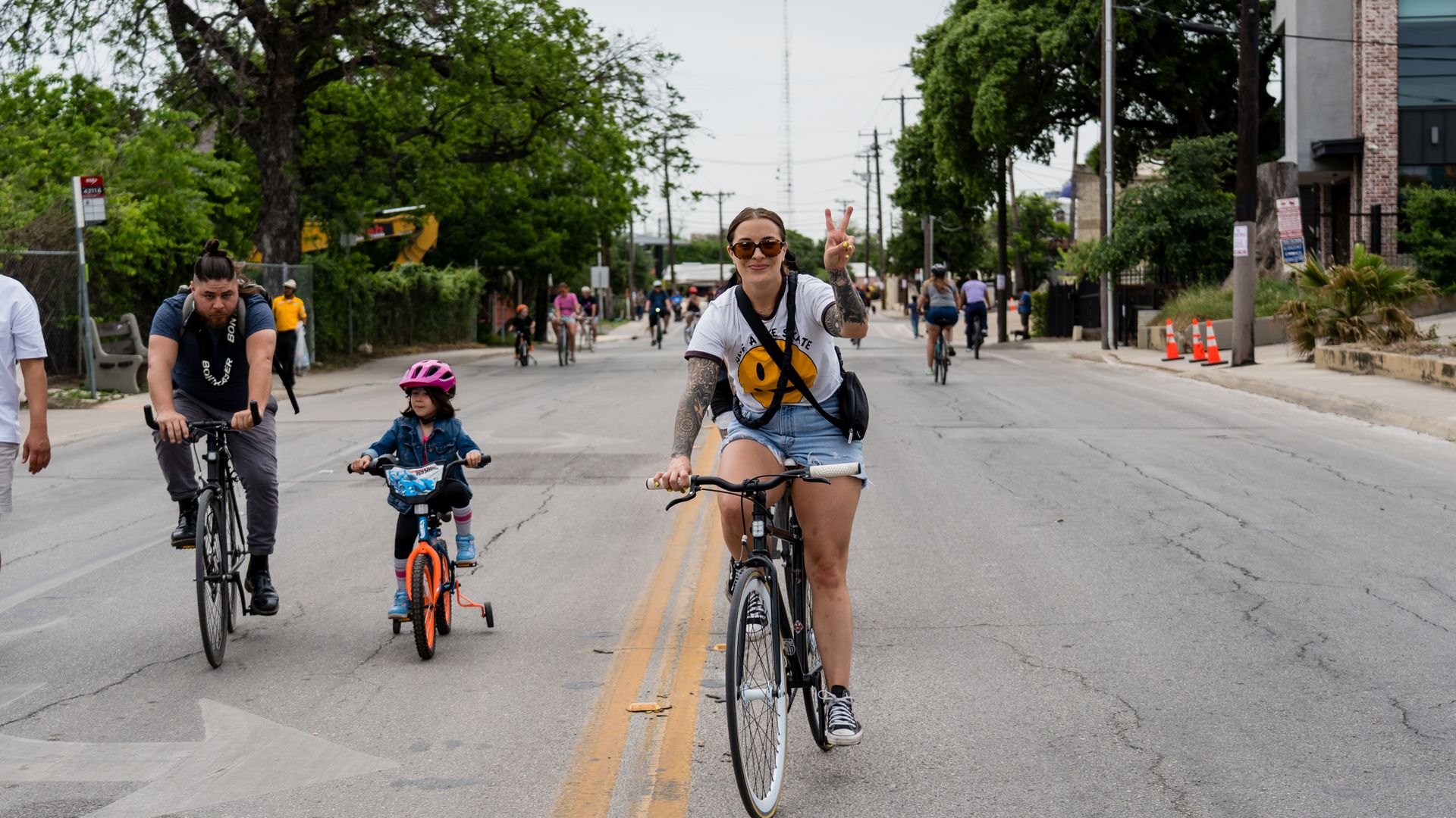 A group of people rides bikes down an empty street.