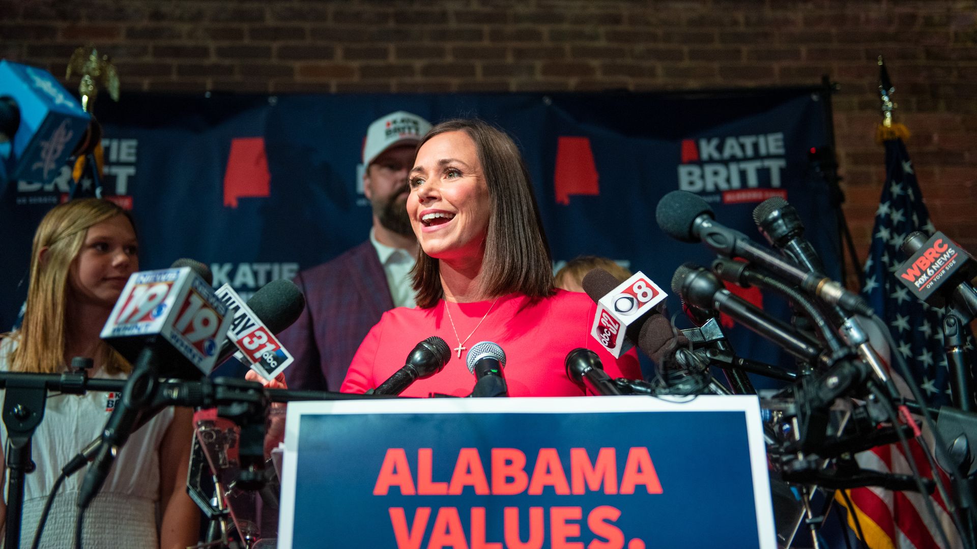 Photo of Katie Britt speaking from a podium at a rally