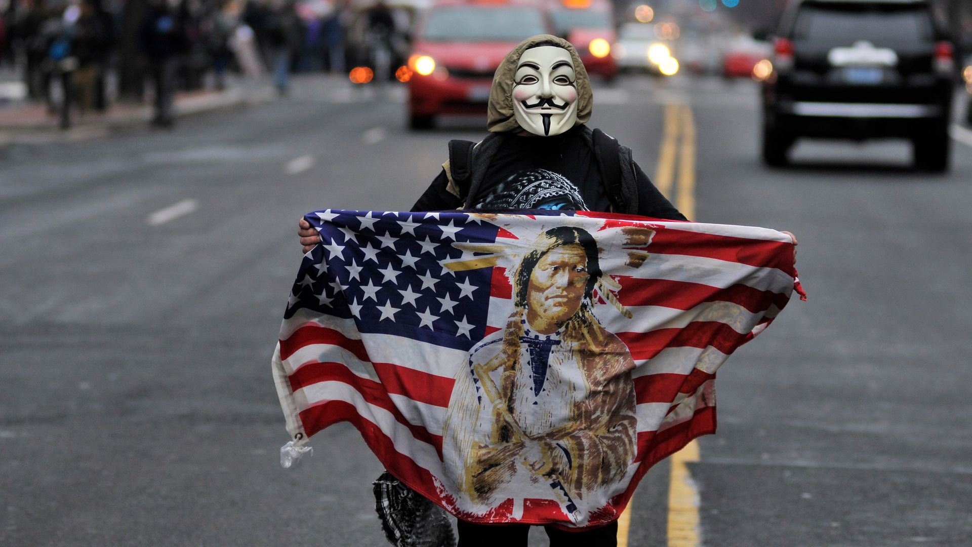 A masked person stands in the street after Trump's inauguration. 