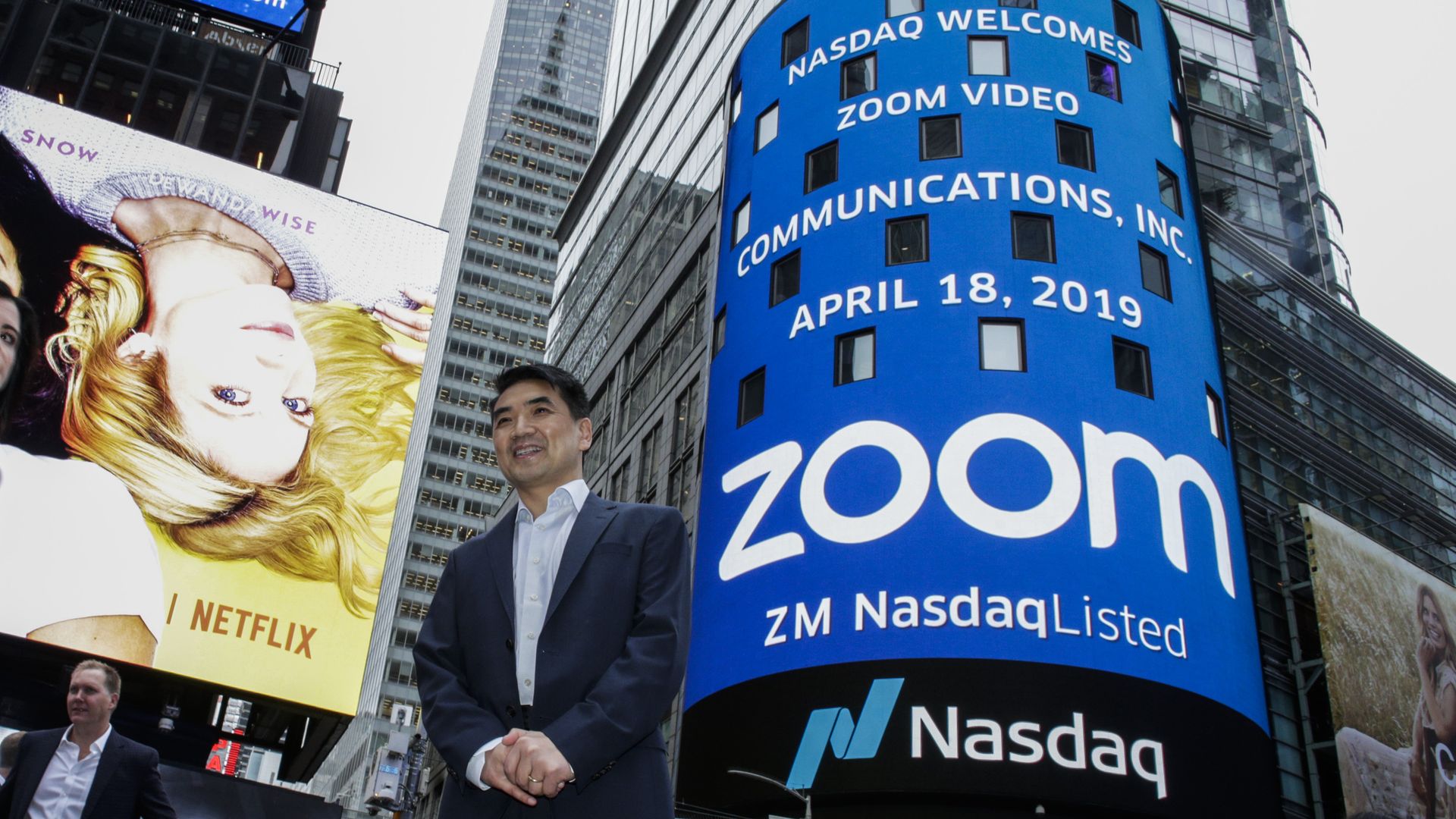 Photo of Zoom founder Eric Yuan on New York street under giant billboard with company name