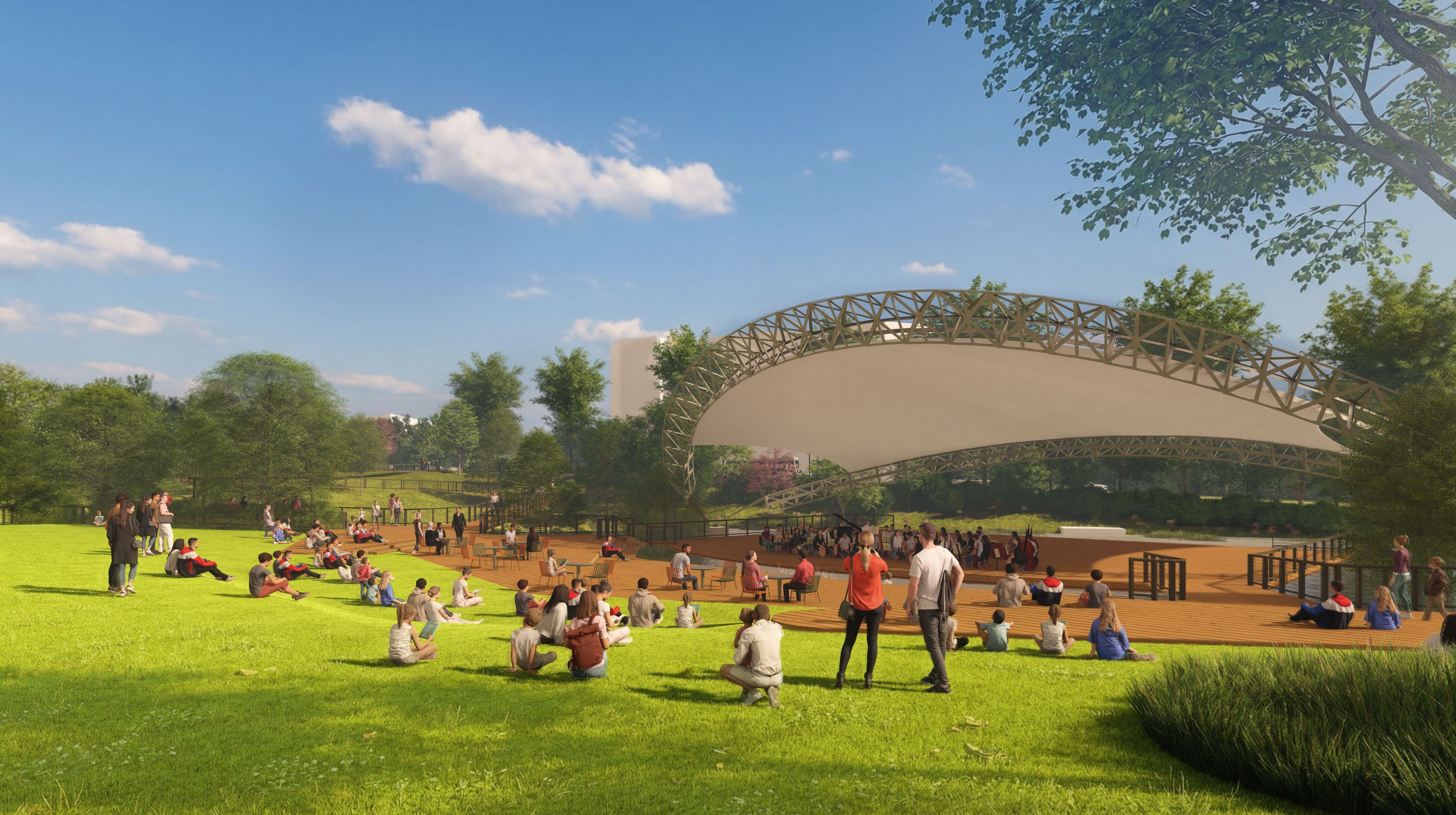 A sunny park with a large curved, lattice-framed pavilion as an open-air stage. People sit on green grass and wooden seating, while trees frame the scene under a blue sky.