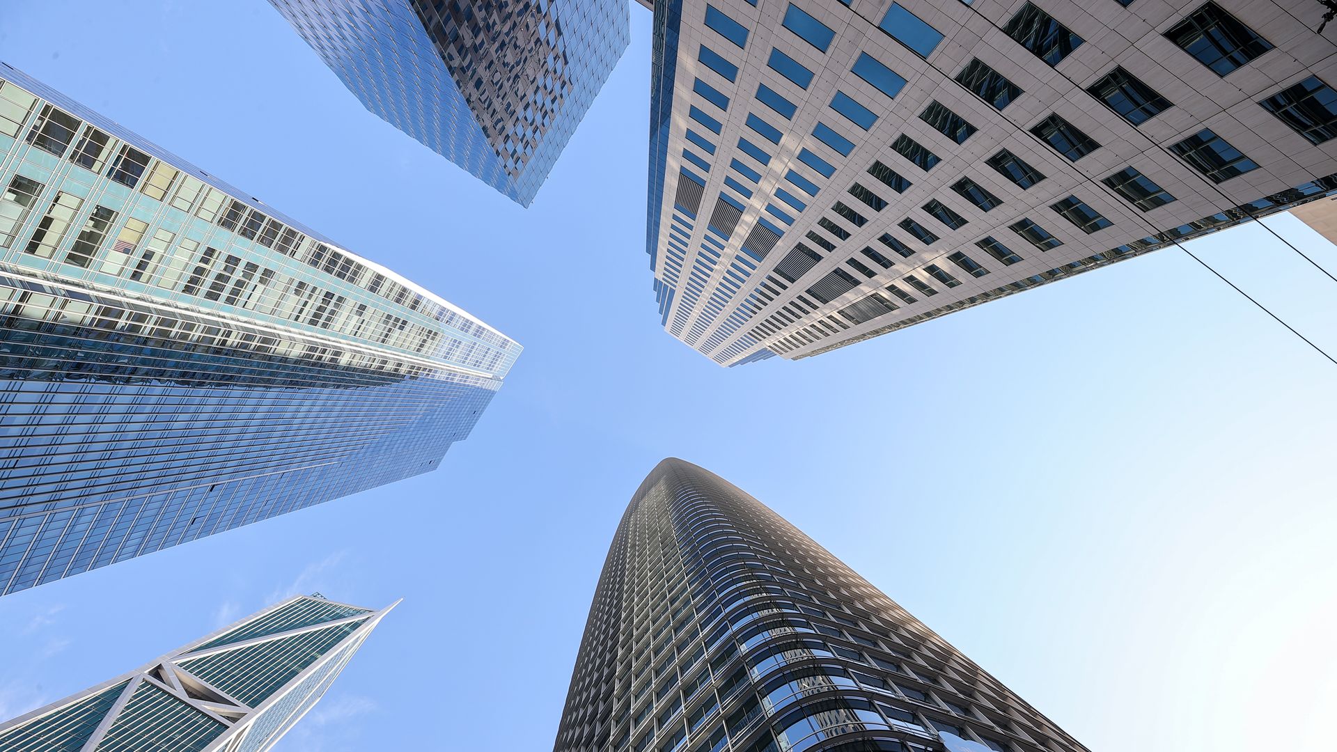 Photo with the perspective looking up at five different skyscrapers