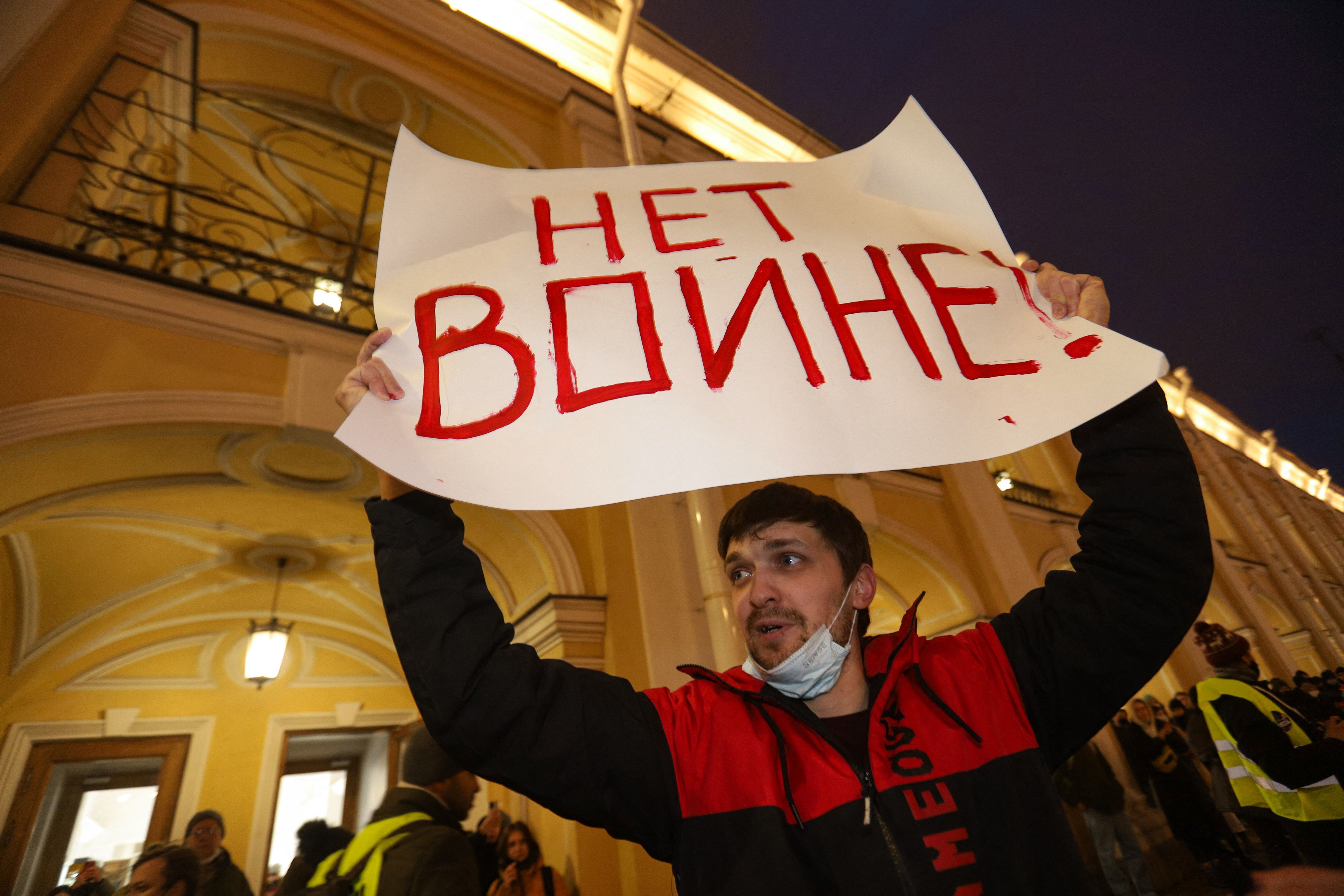 A man holding up a placard reading "No to war!" in Saint Petersburg