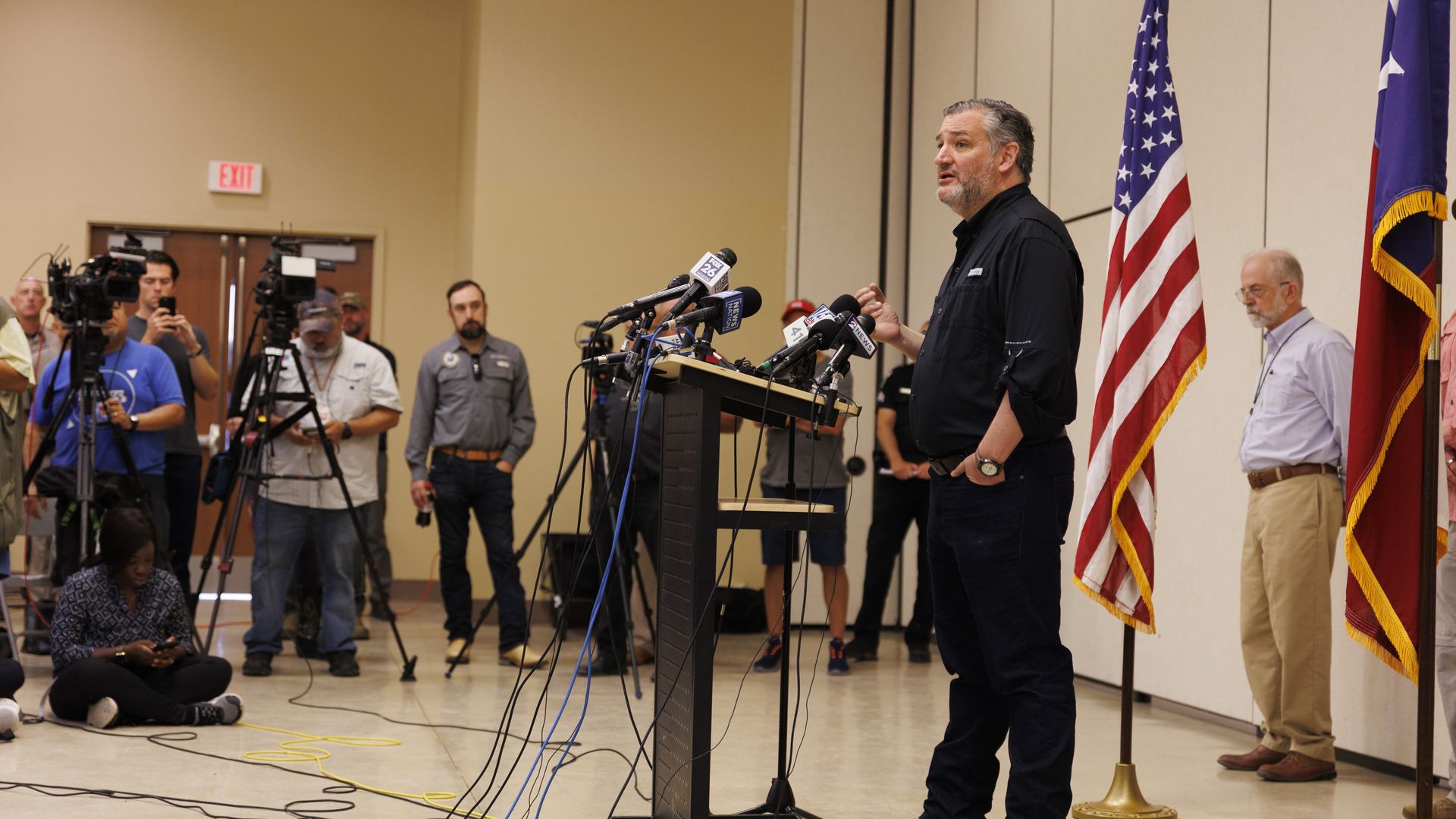 Ted Cruz speaks into several microphones from behind a lectern at a news conference.