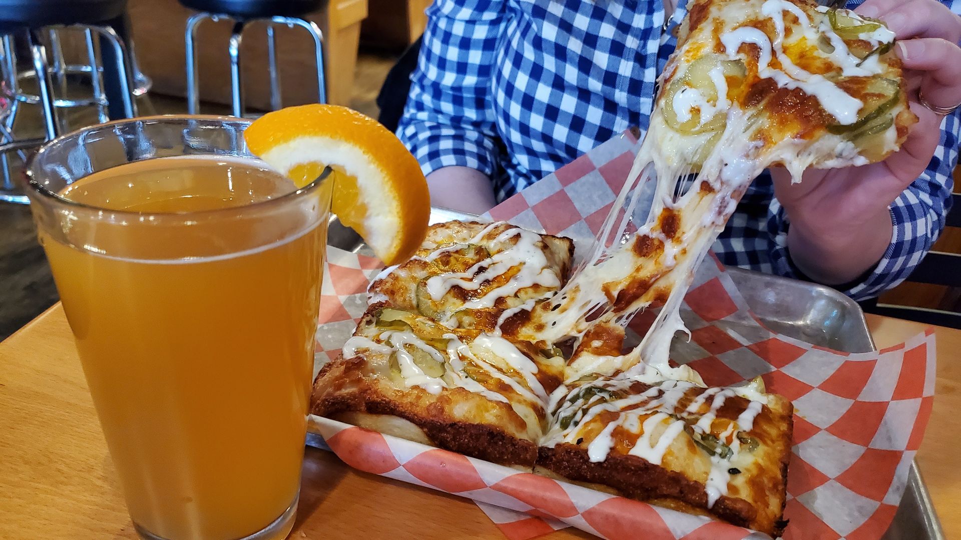 Cheese stretches as Alissa pulls a piece of pizza off the tray