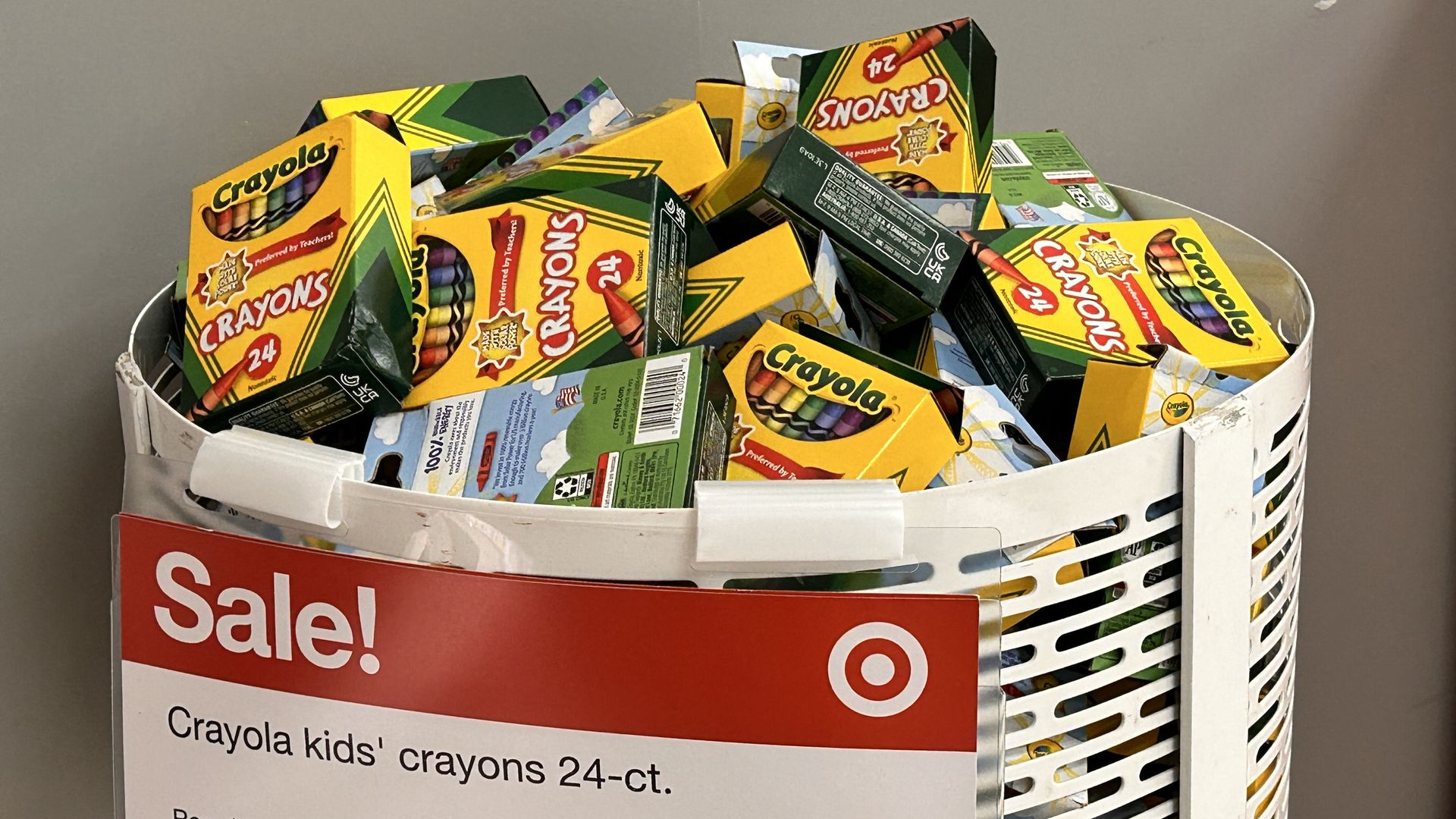 White basket filled with multiple boxes of Crayola 24-count crayons on sale for 50 cents, marked down from $1.49, at a Target store.