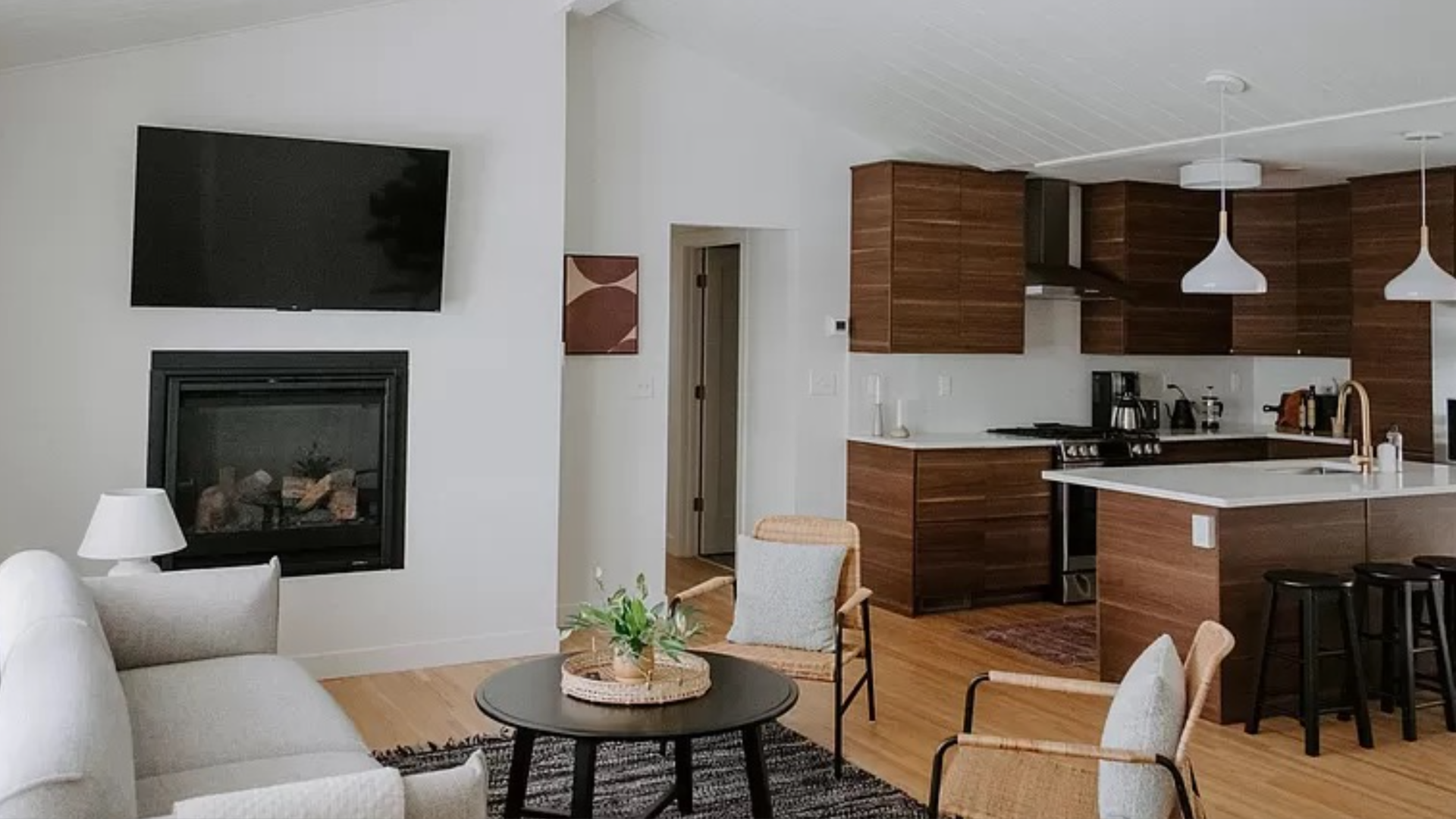 A living room with white walls and brown cabinets in the kitchen.
