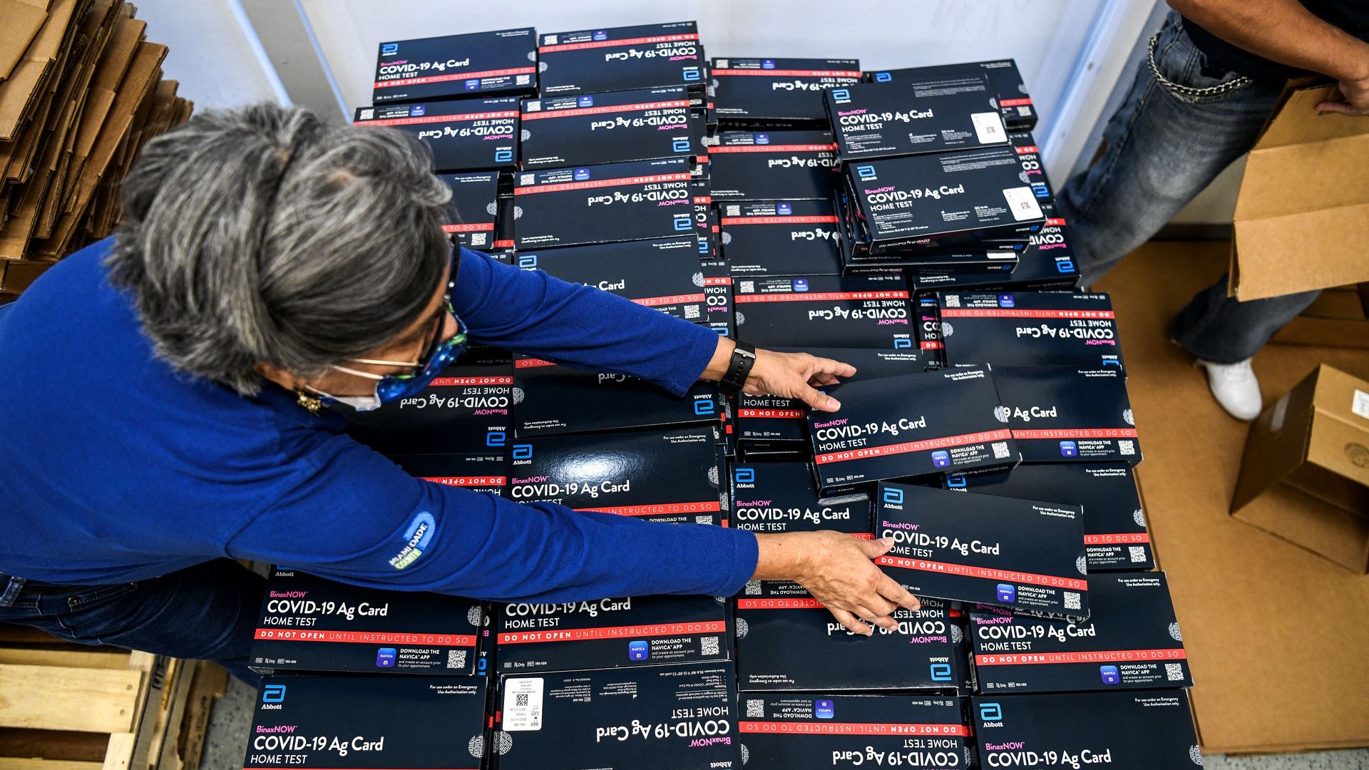 Picture of a person holding at-home covid tests