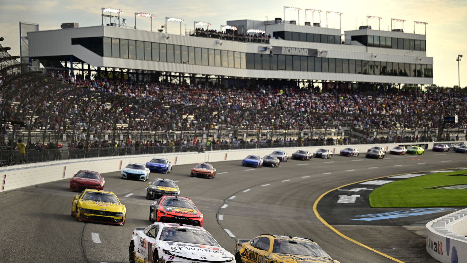 a racetrack filled with racing cars and a crowd looking on