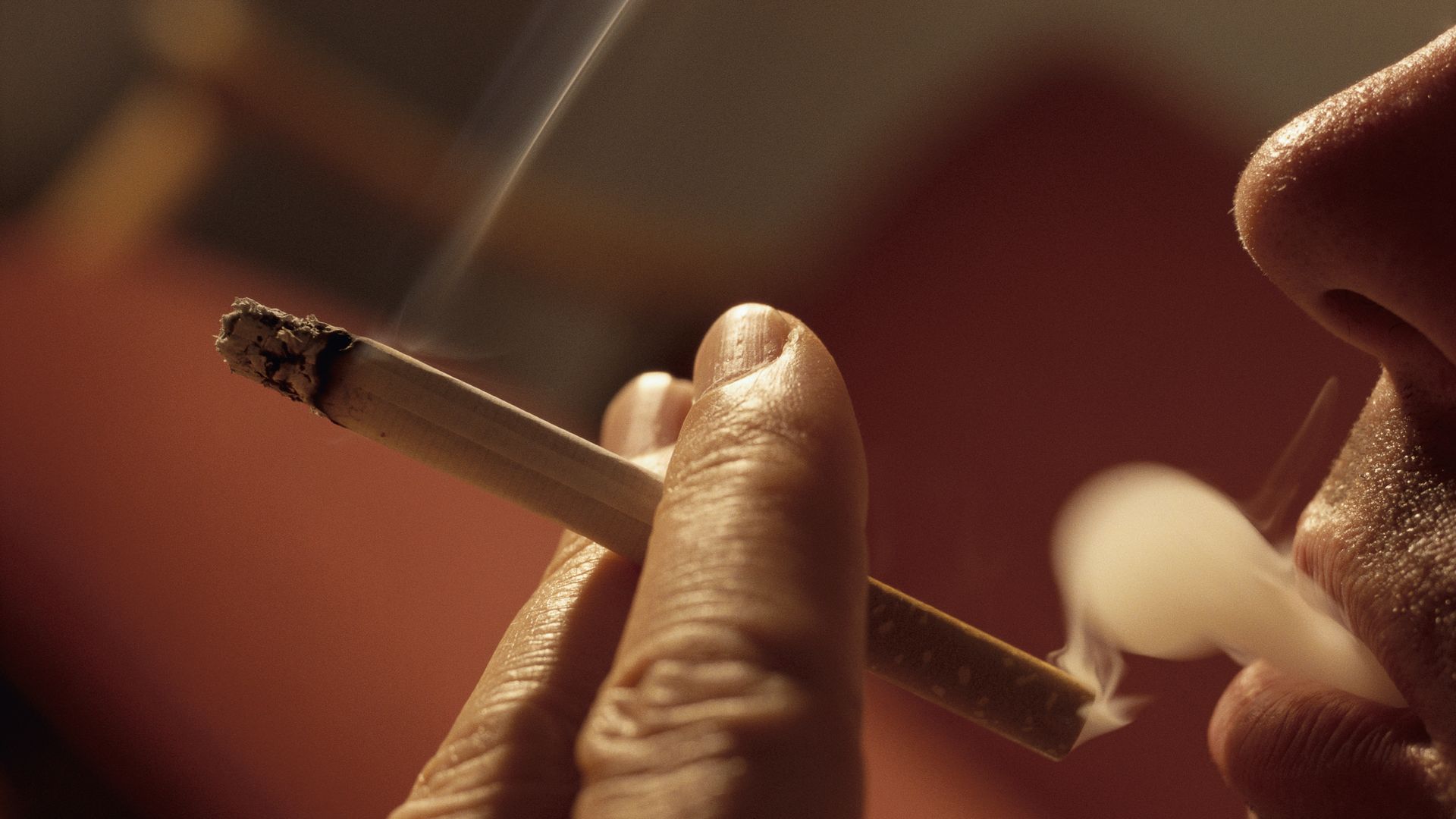 Photo of closeup of man puffing cigarette