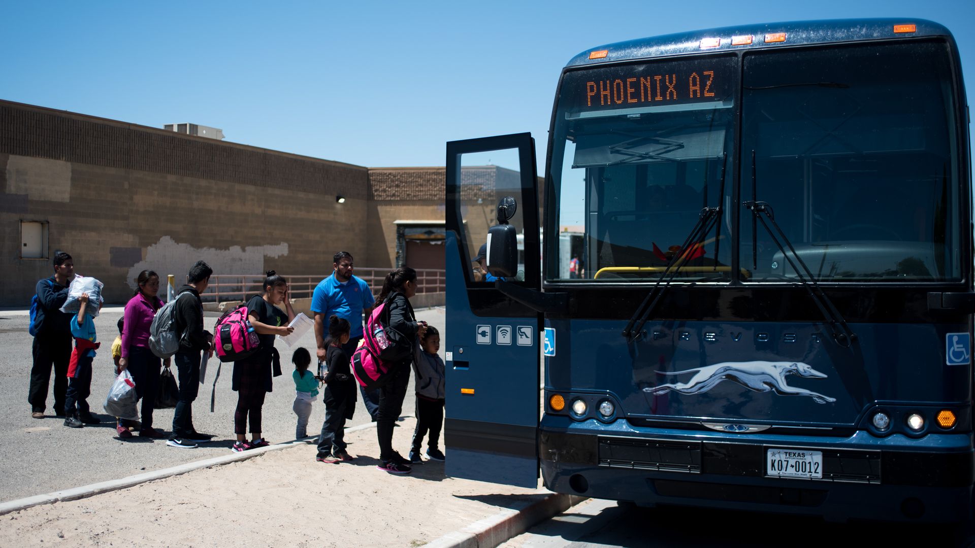 This image shows a line of children boarding a bus.