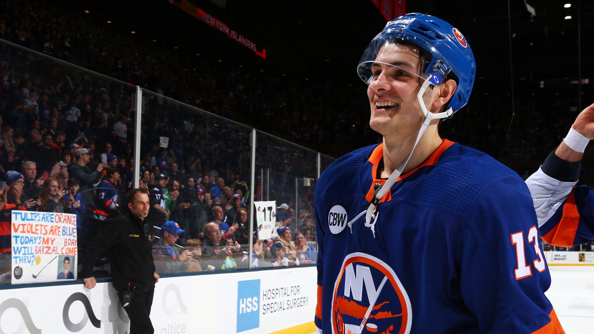 An islanders player skating on the ice, smiling