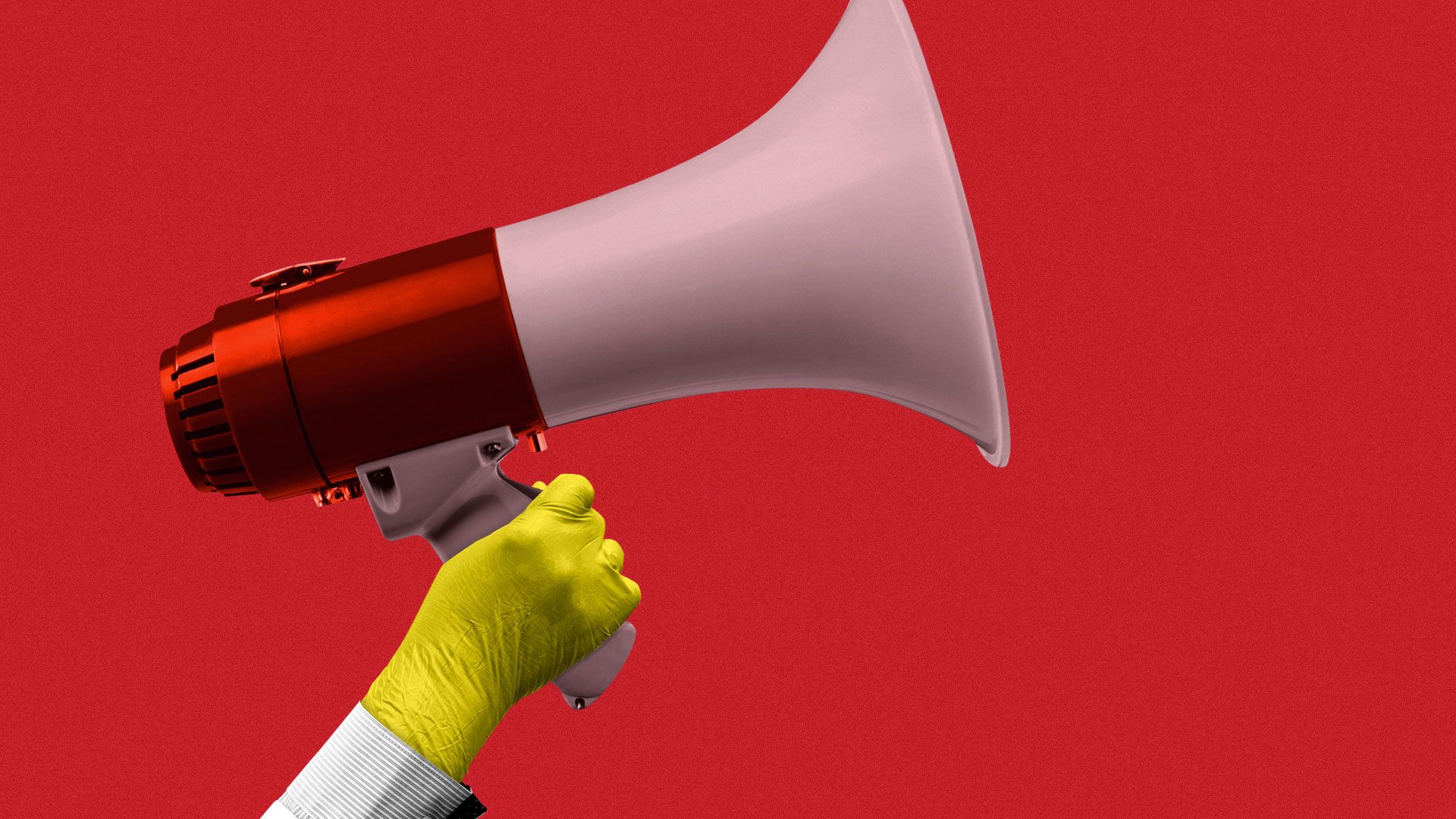 A hand holding up a red and white megaphone.