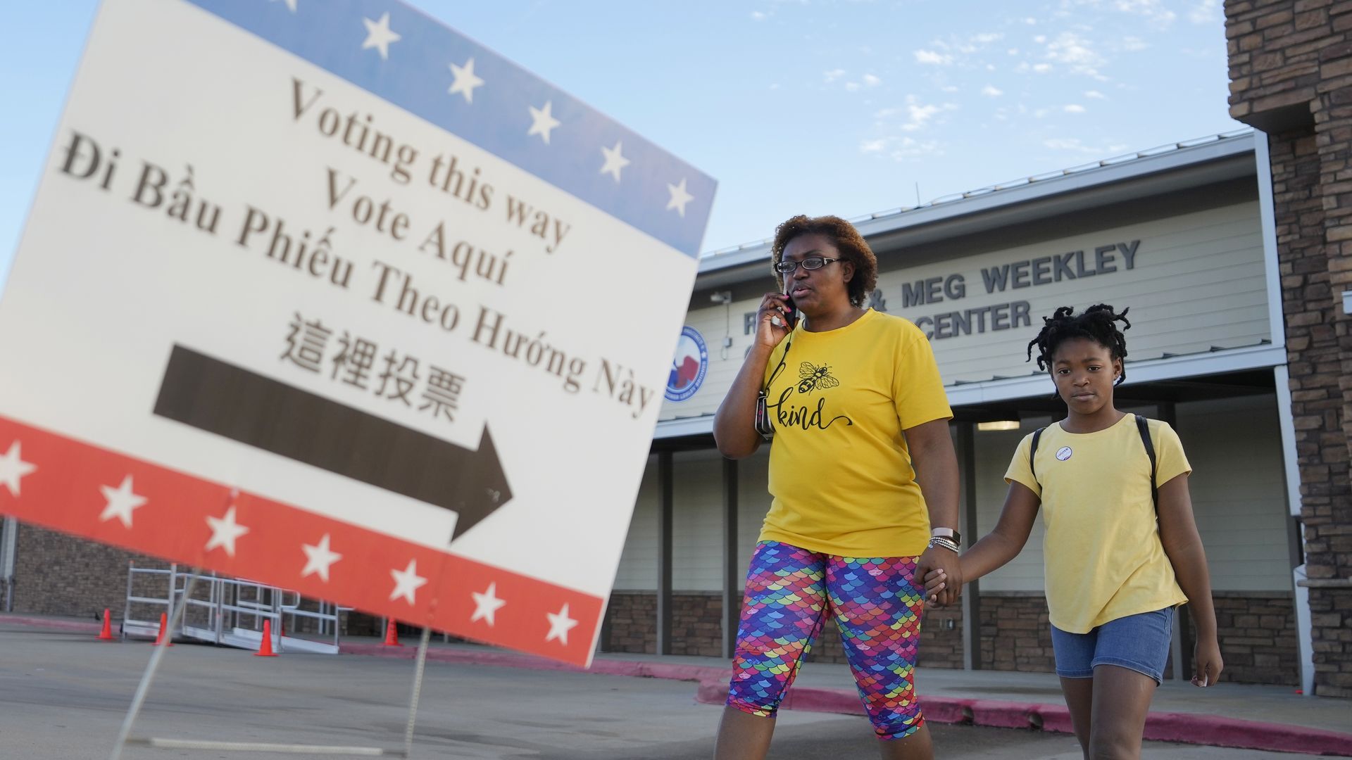 A mother and daughter walk out of a Houston-area polling location
