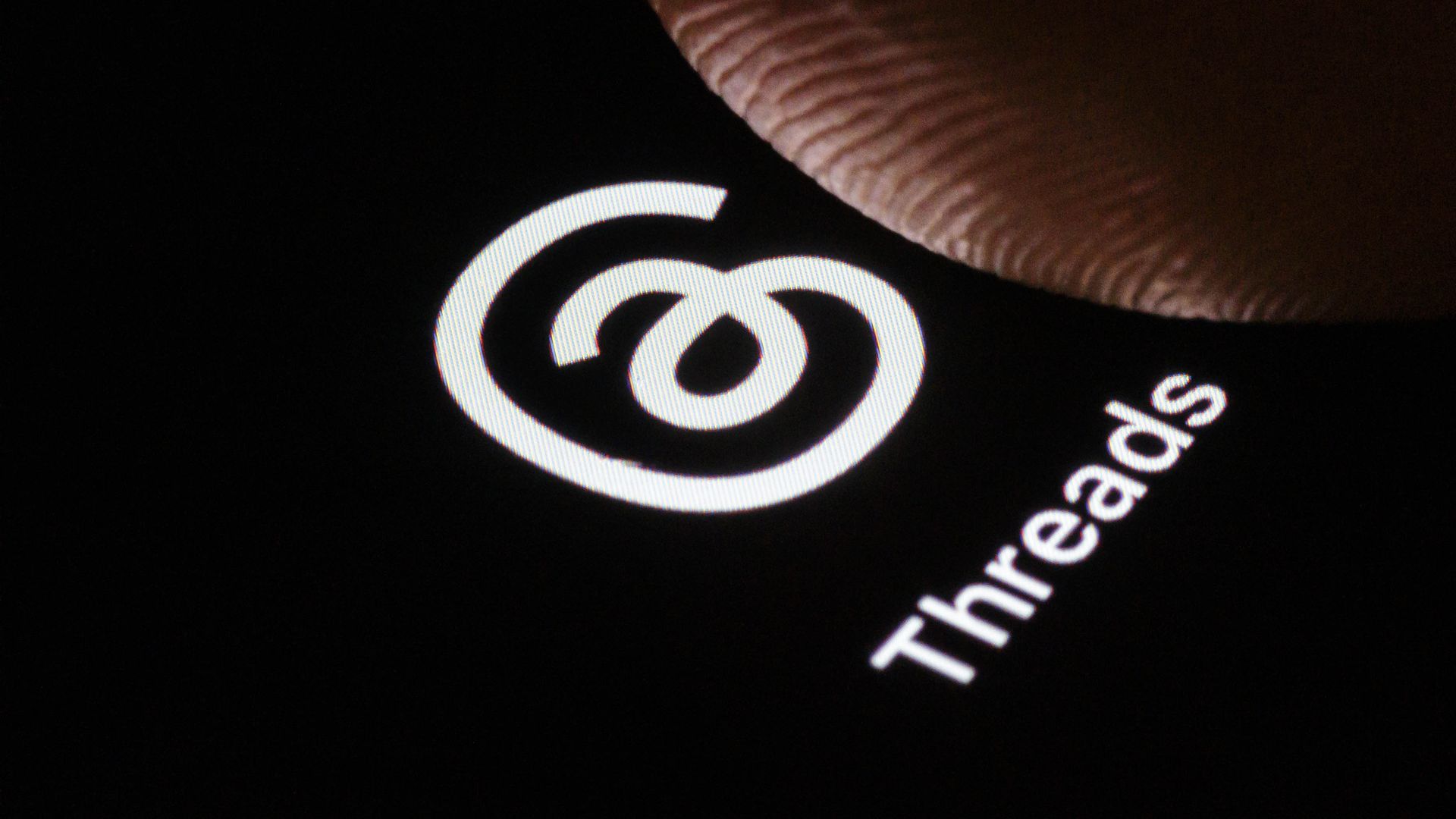 A photo illustration of the logo of Threads, a social network of Meta.