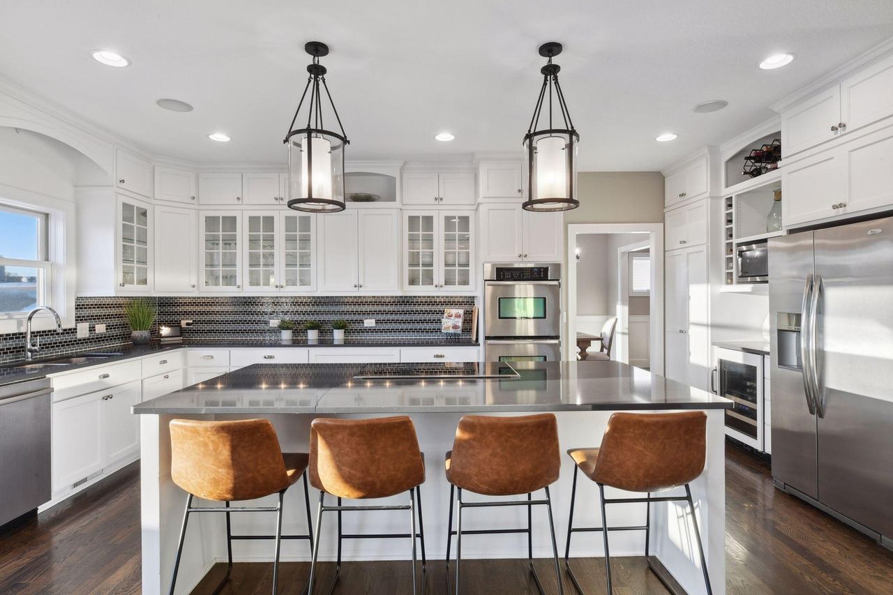 spacious modern kitchen with island seating and tile backsplash