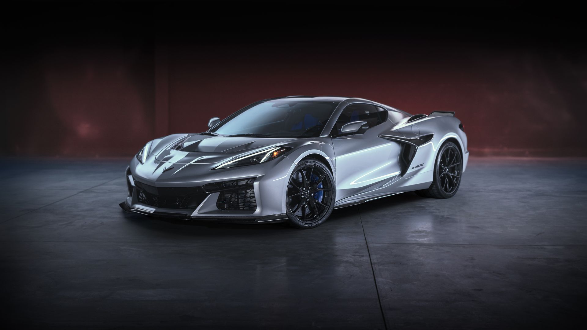 A silver sports car with a dark maroon background