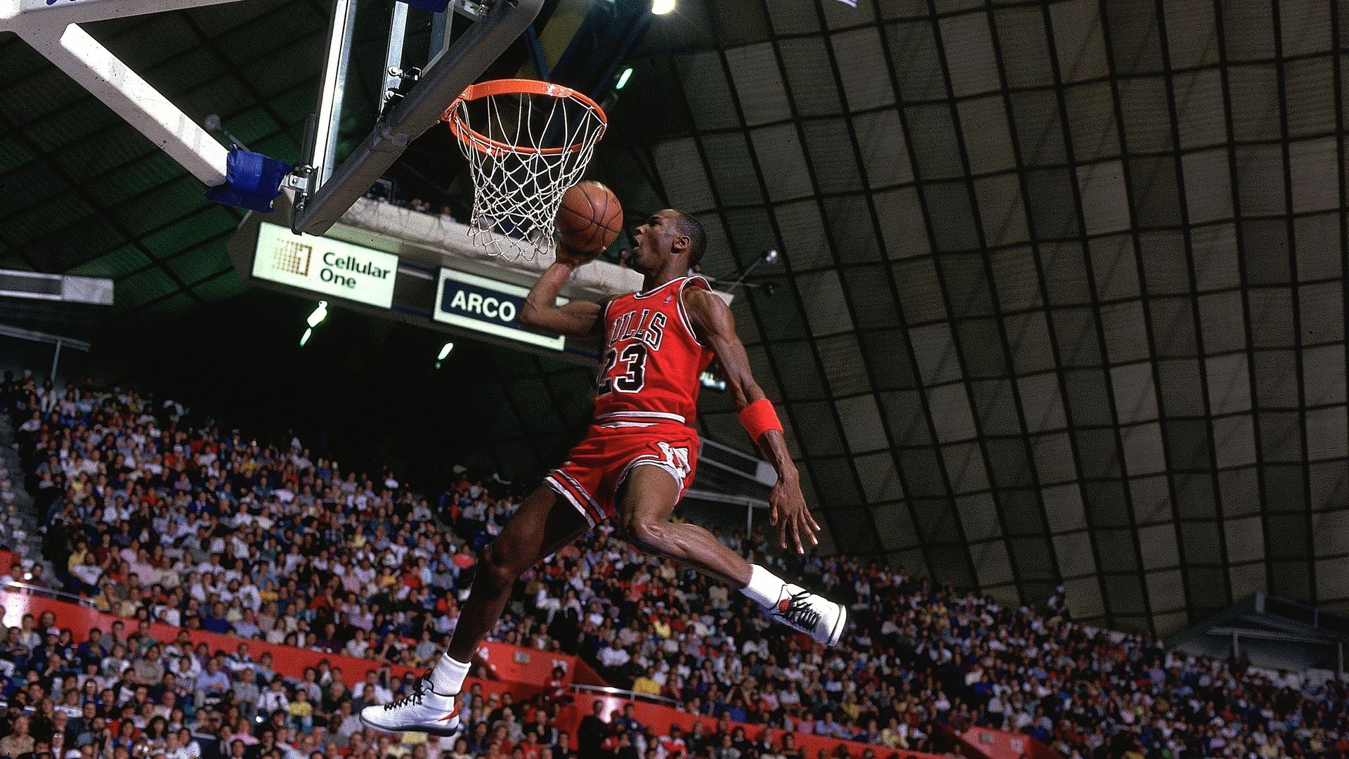 Photo of a man jumping on a basketball court.