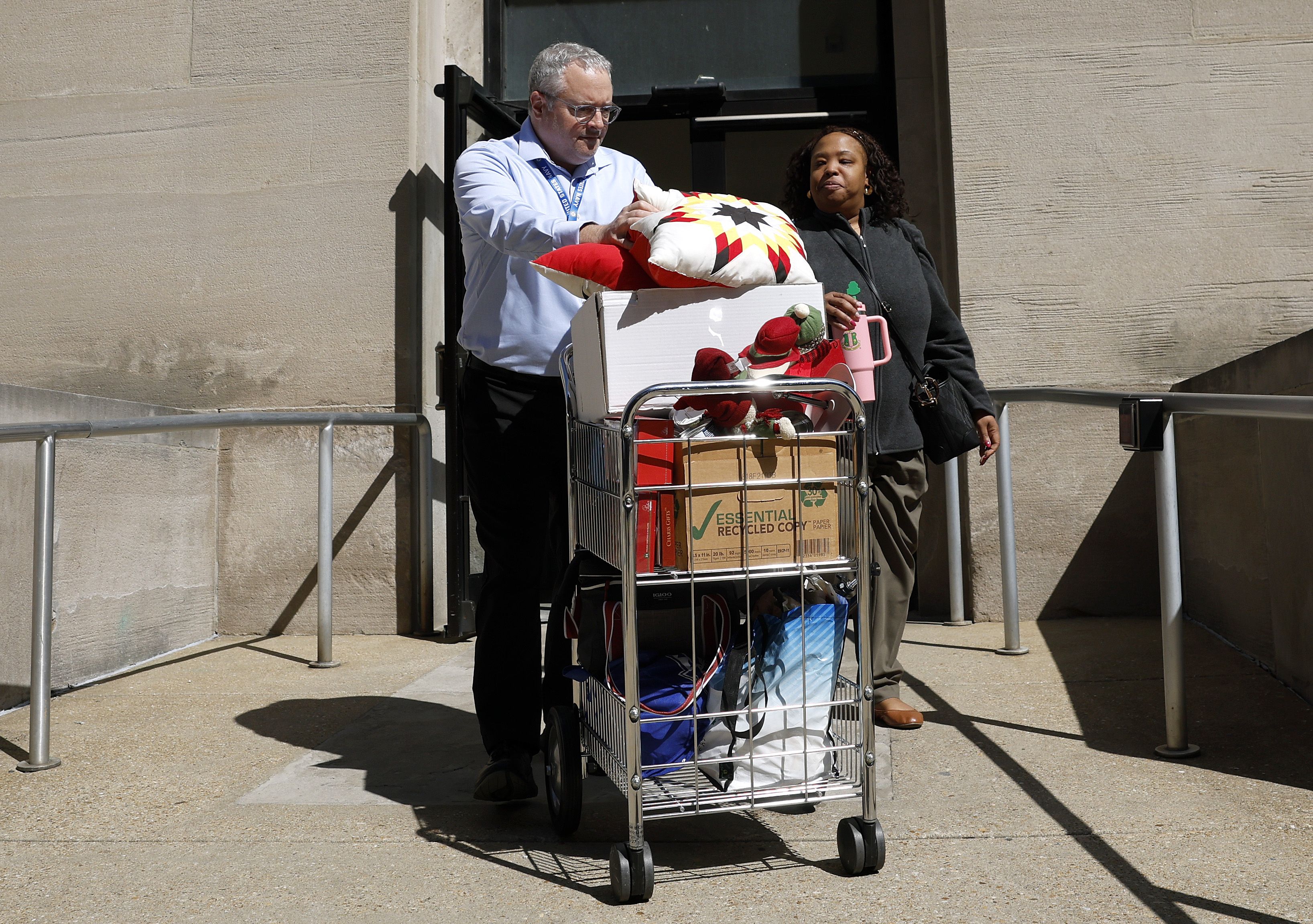 WASHINGTON, DC - APRIL 01: Fired employees of the Department of Health and Human Services (HHS) take personal belongings with them as they leave HHS Mary E. Switzer Memorial Building on April 01, 2025 in Washington, DC. Widespread layoffs began today across Health and Human Service Administration of