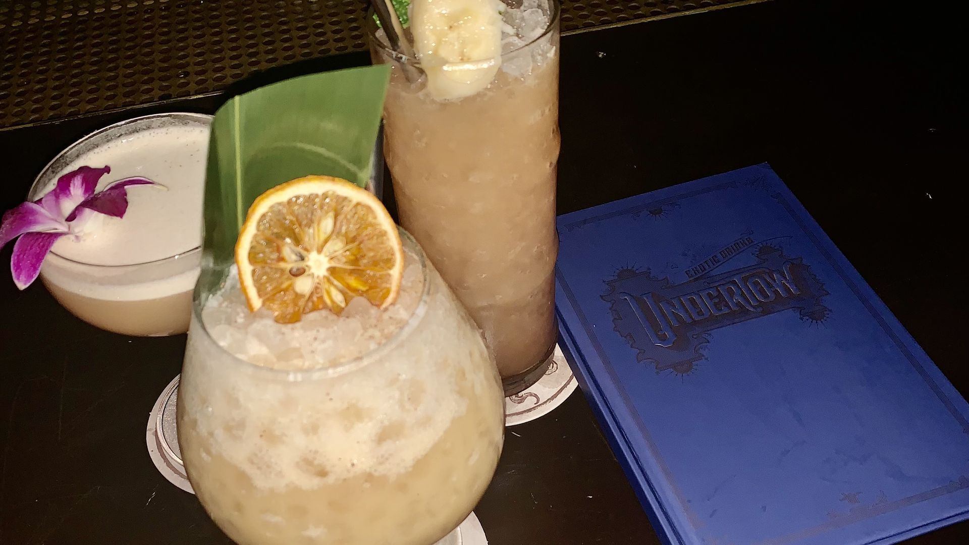 Three drinks around a cocktail menu.
