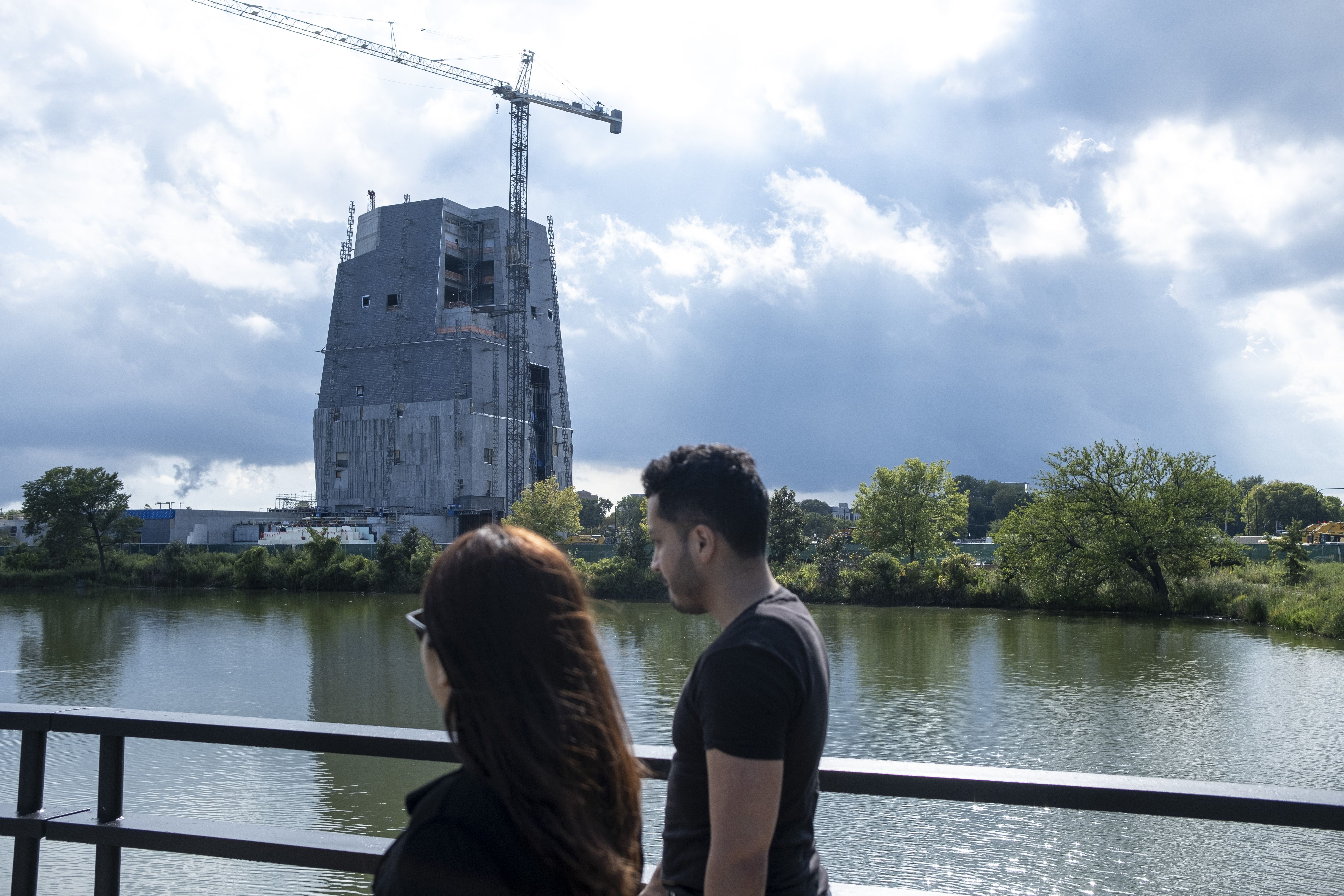 Photo of a building tower being constructed near water 