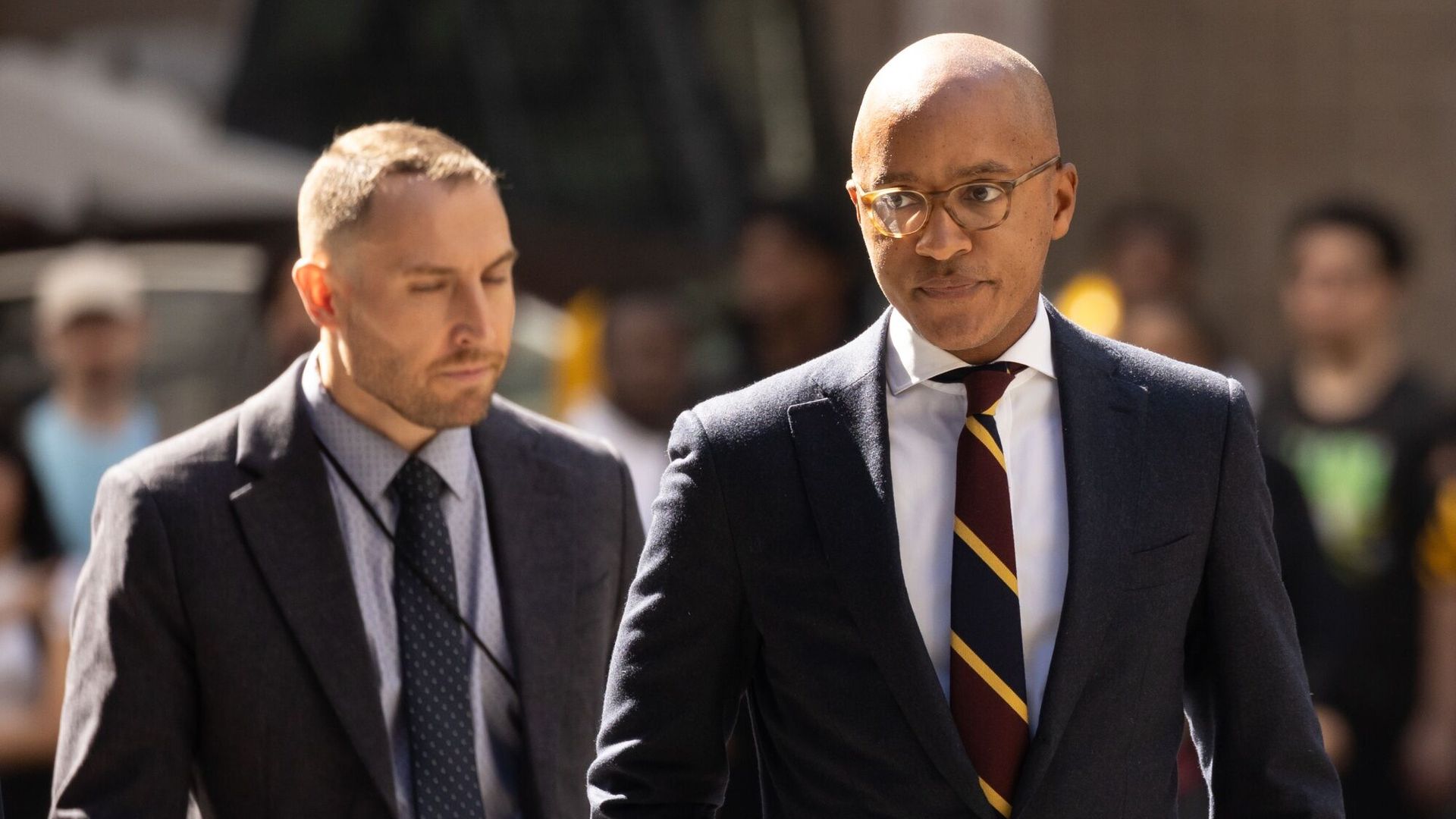 Two men, US attorney Damian Williams on the right, walking outside a courthouse.