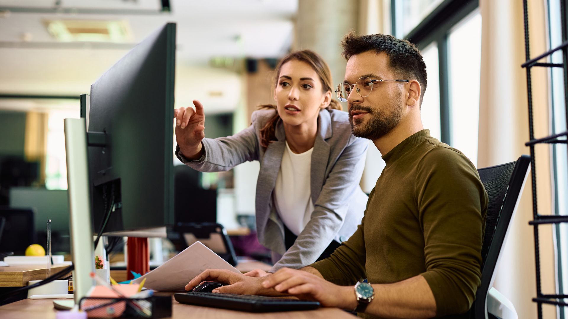 A woman and a man working at the computer.