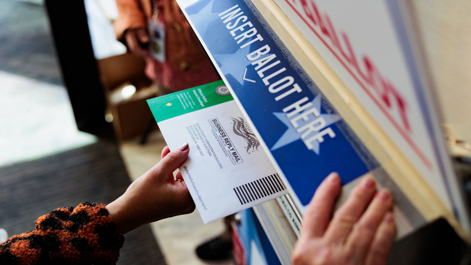 A person drops off a mail-in ballot on October 15, 2024 in Doylestown, Pennsylvania. Registered voters in Pennsylvania can vote "On Demand" by requesting, a mail-in or absentee ballot filing it out and dropping it off all in one visit to their county election office or other designated location. (Ph