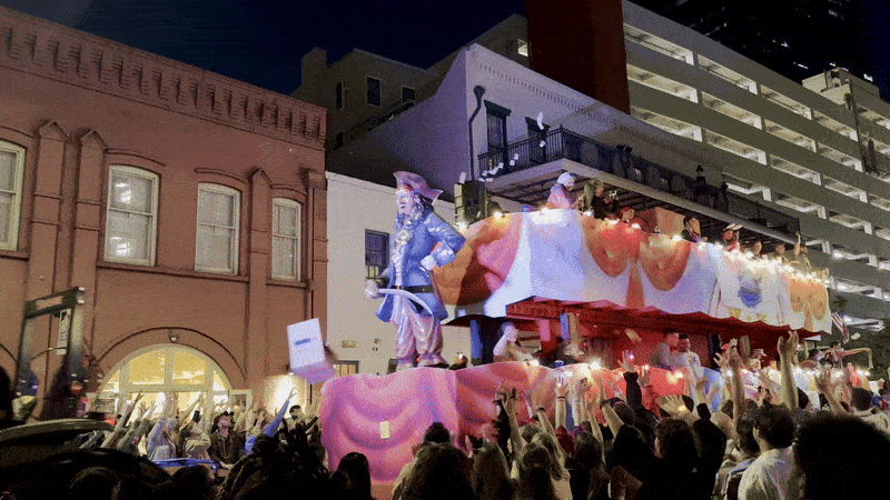 Image shows a double decker float with a crowd around it.