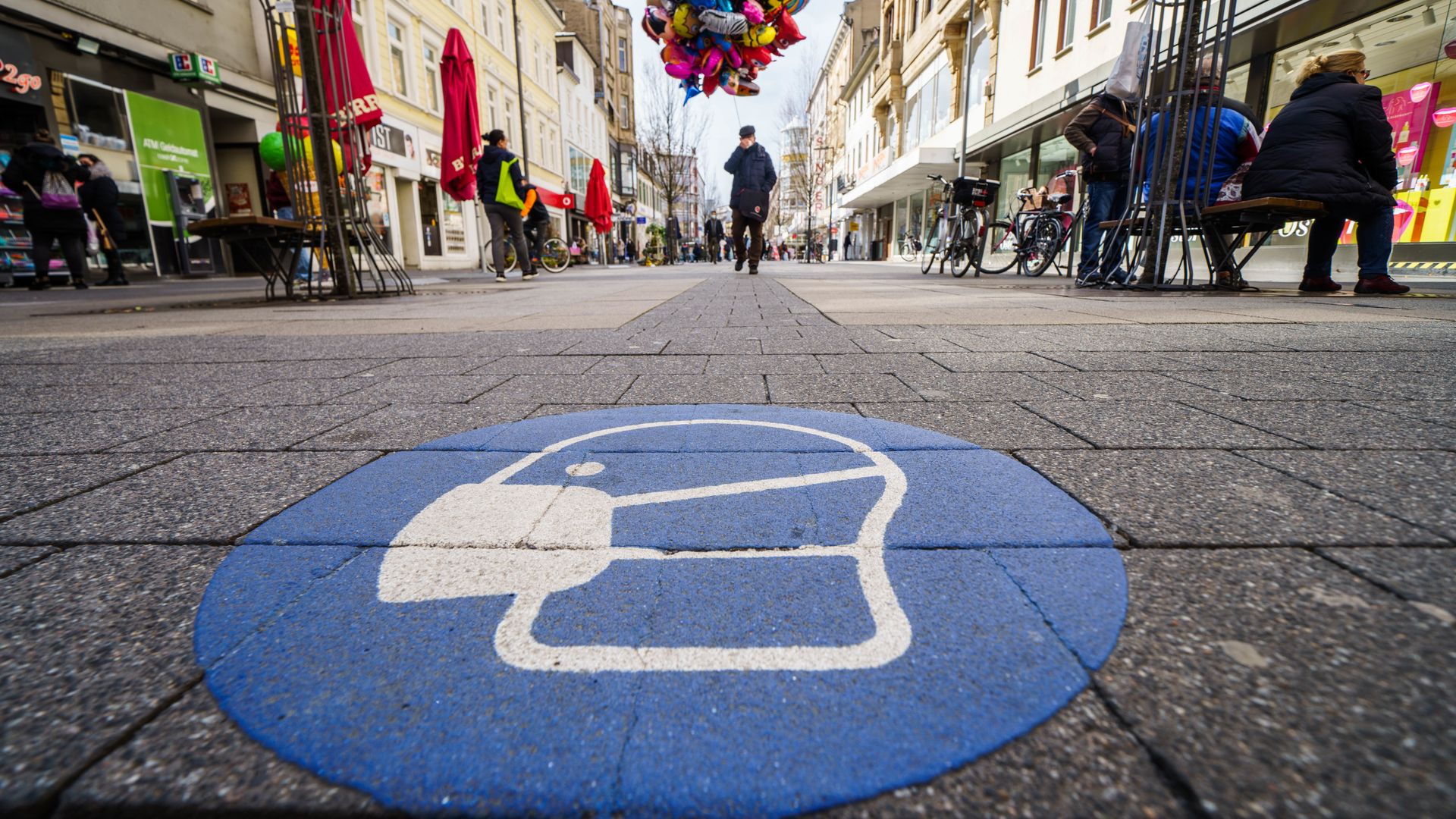 A symbol for the mask obligation is applied on the pavement of the pedestrian zone in the Offenbach city 