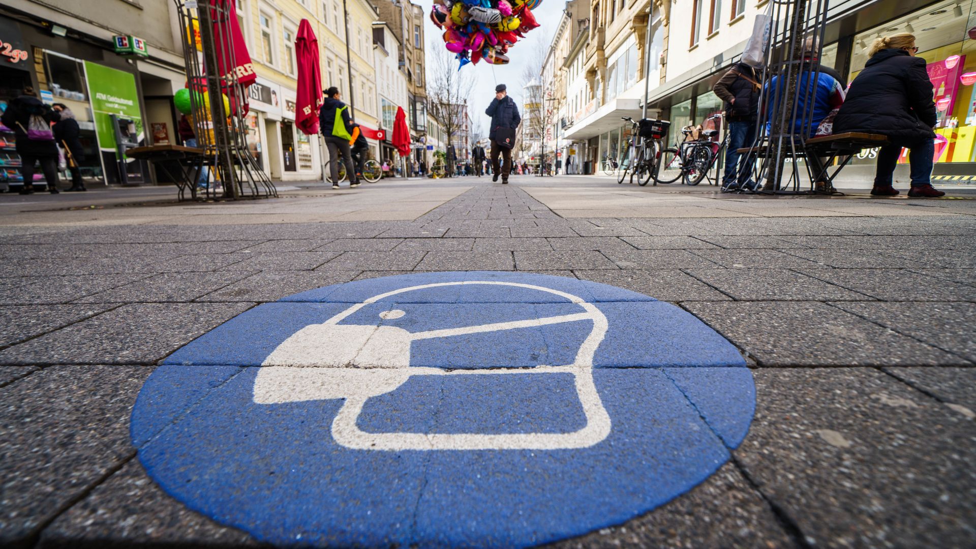A symbol for the mask obligation is applied on the pavement of the pedestrian zone in the Offenbach city