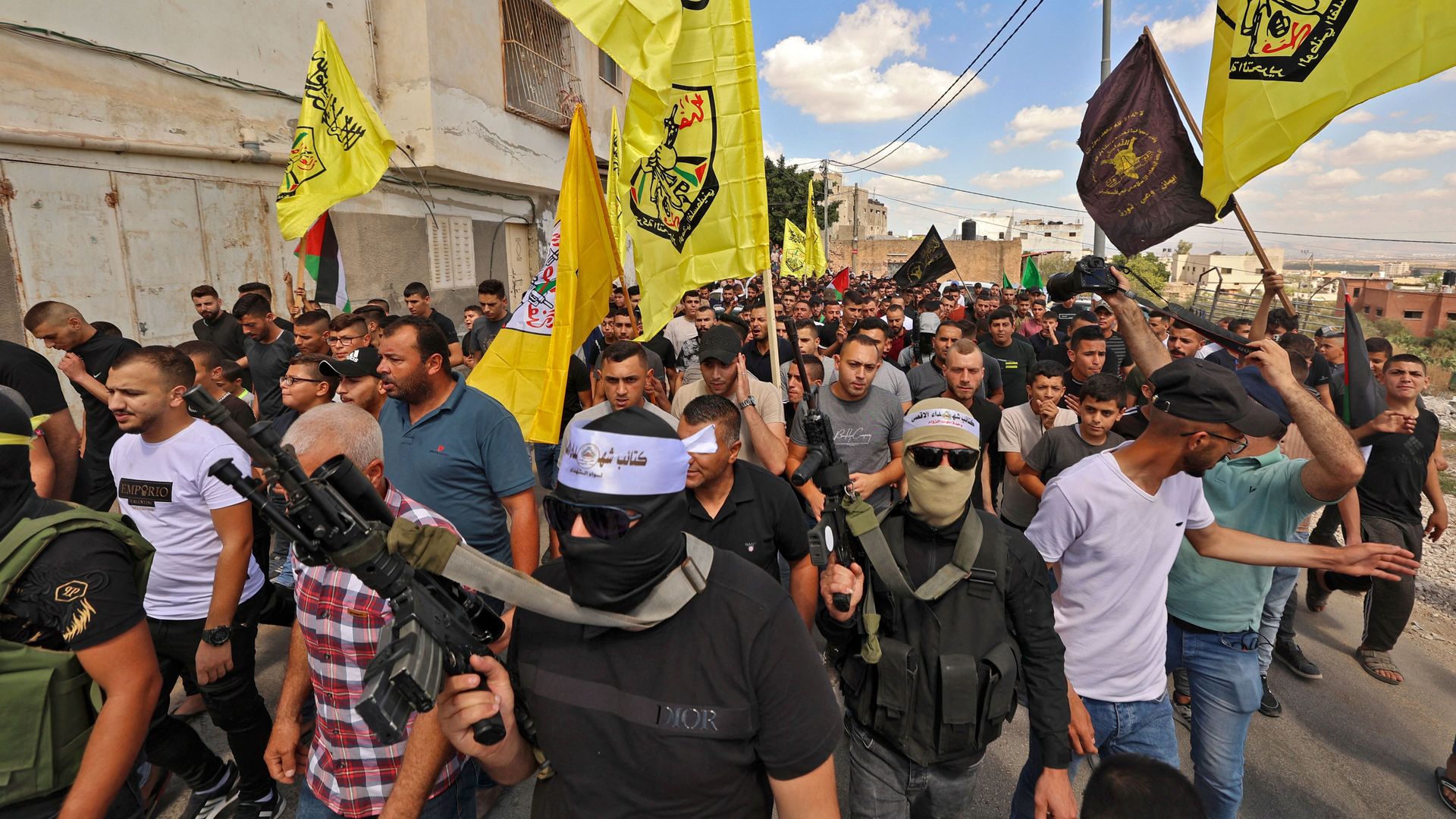 Palestinian fighters and civilians march in the village of Kafr Dan, near Jenin, in the occupied West Bank on Sept. 14.