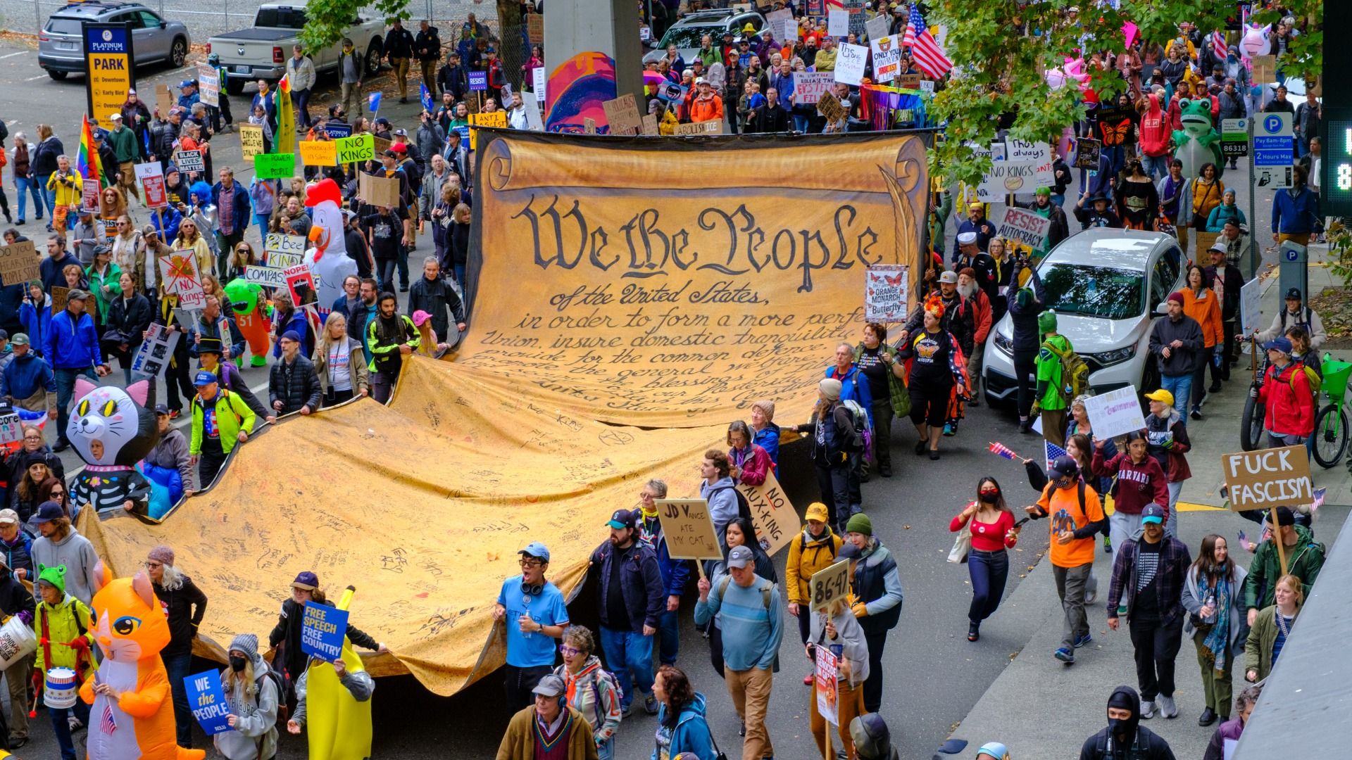 Protesters carry a giant "We the People" banner through the streets of Seattle. 