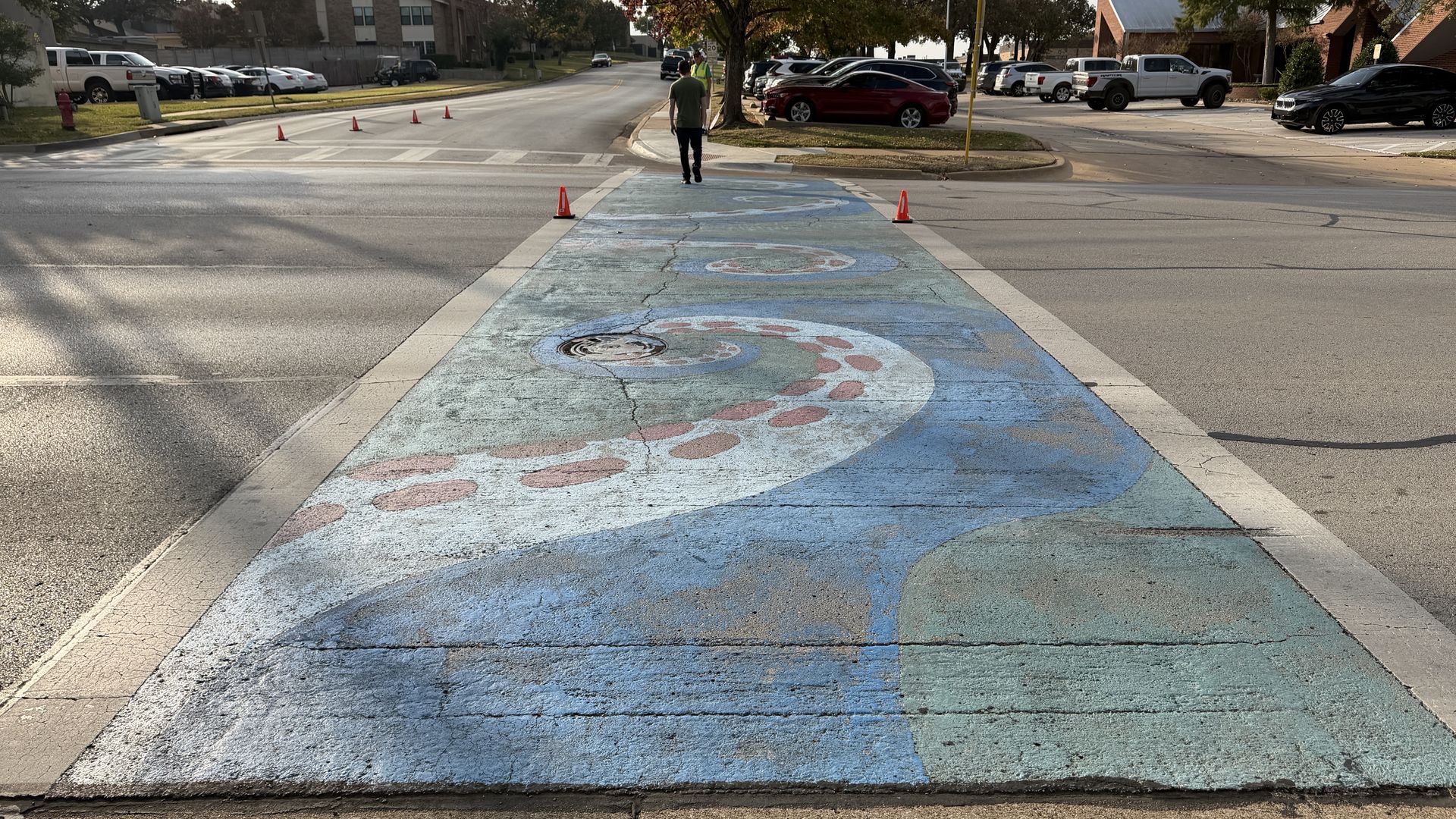 A crosswalk painted with a large blue octopus design