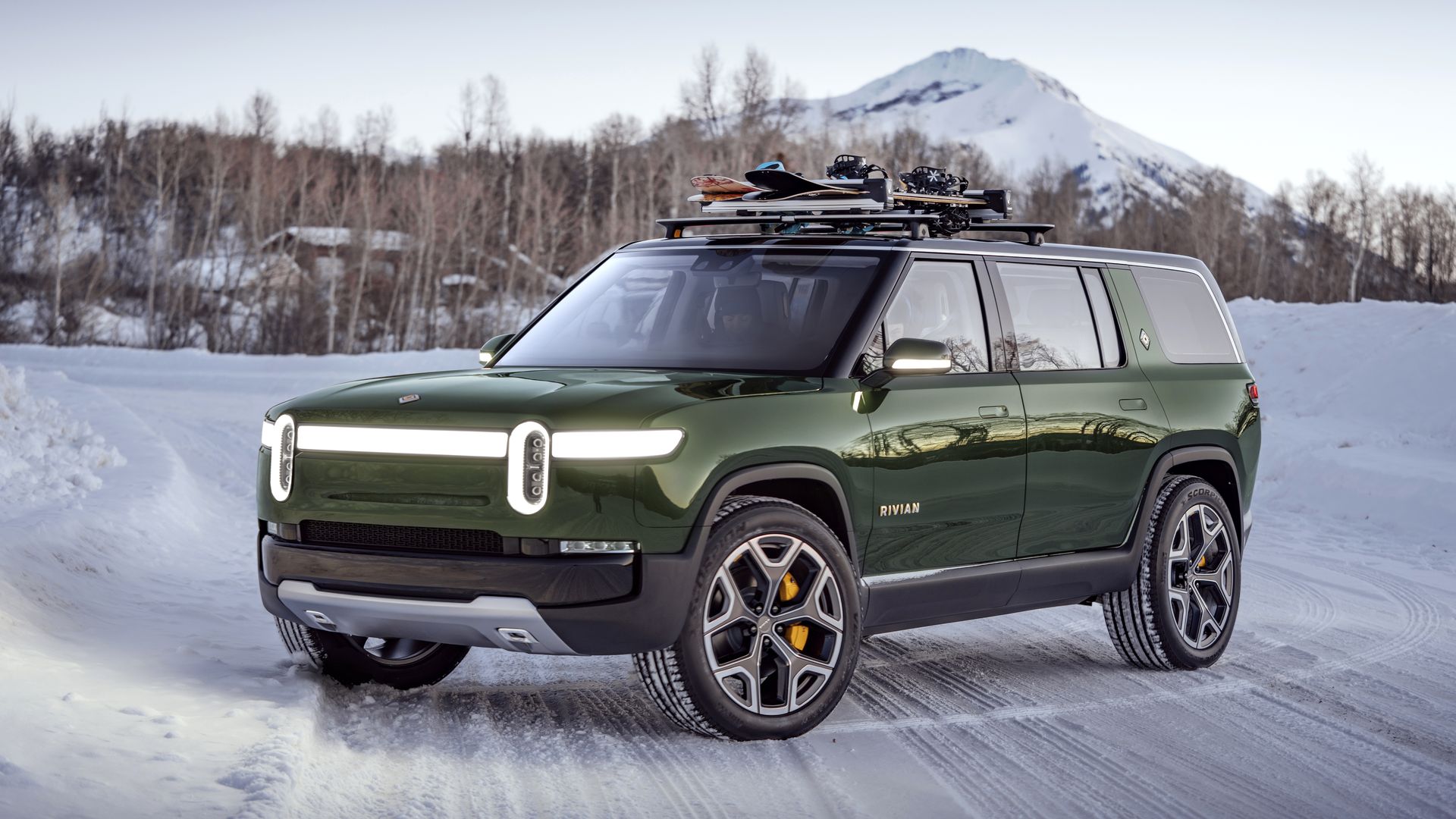 Image of green Rivian R2S sport utility in a snowy environment. 