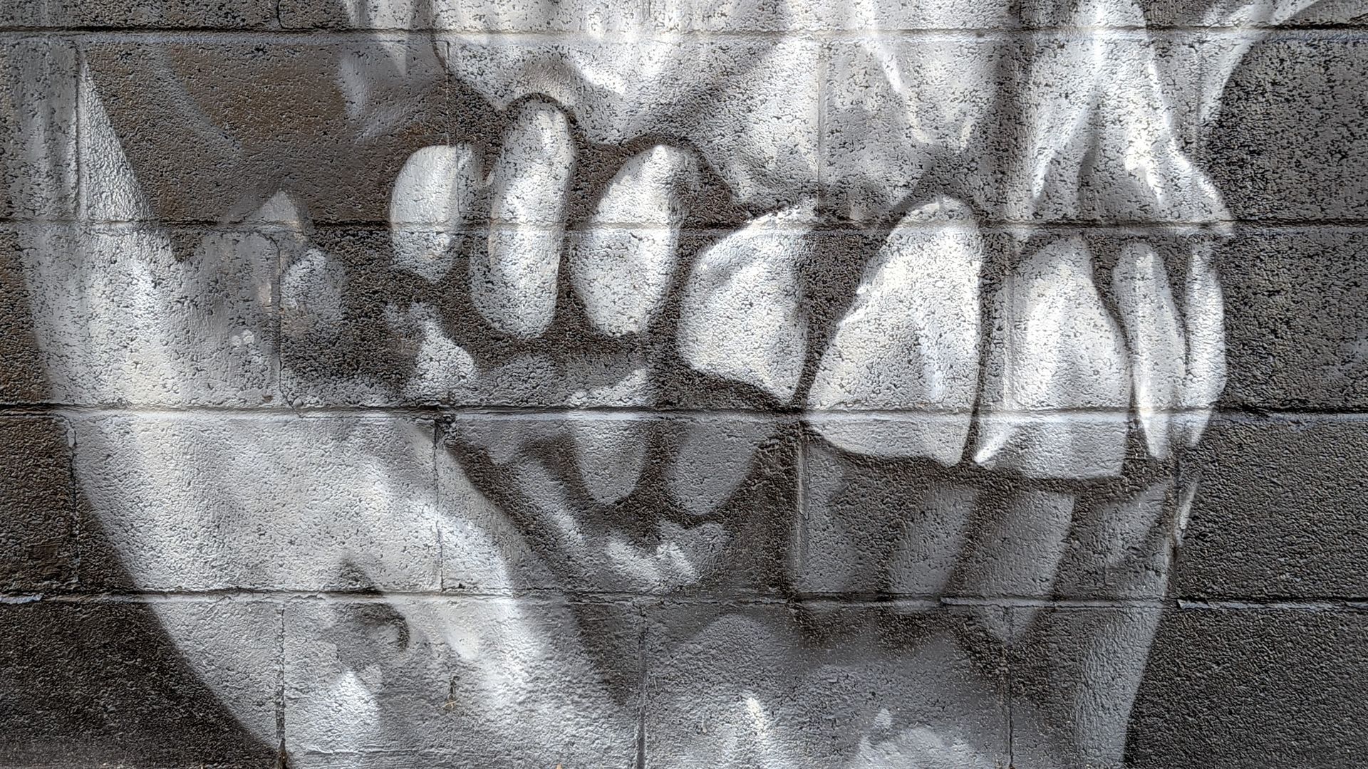 A skull's teeth are painted on bricks.