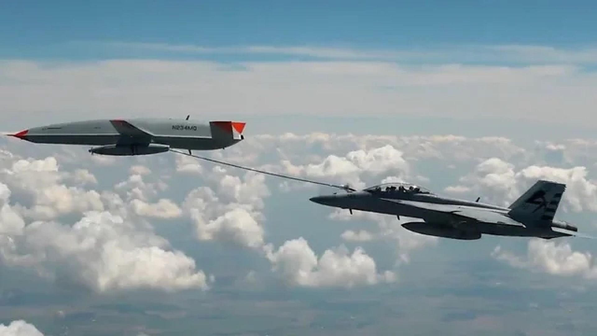 An unmanned aircraft refueling a Navy fighter jet in midair for the first time.