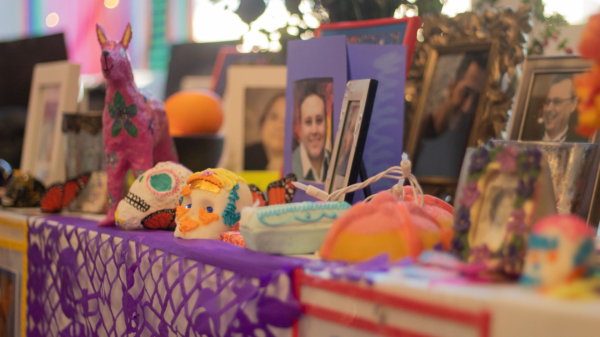 a shrine for Day of the Dead is decorated and has pictures of people who have passed away