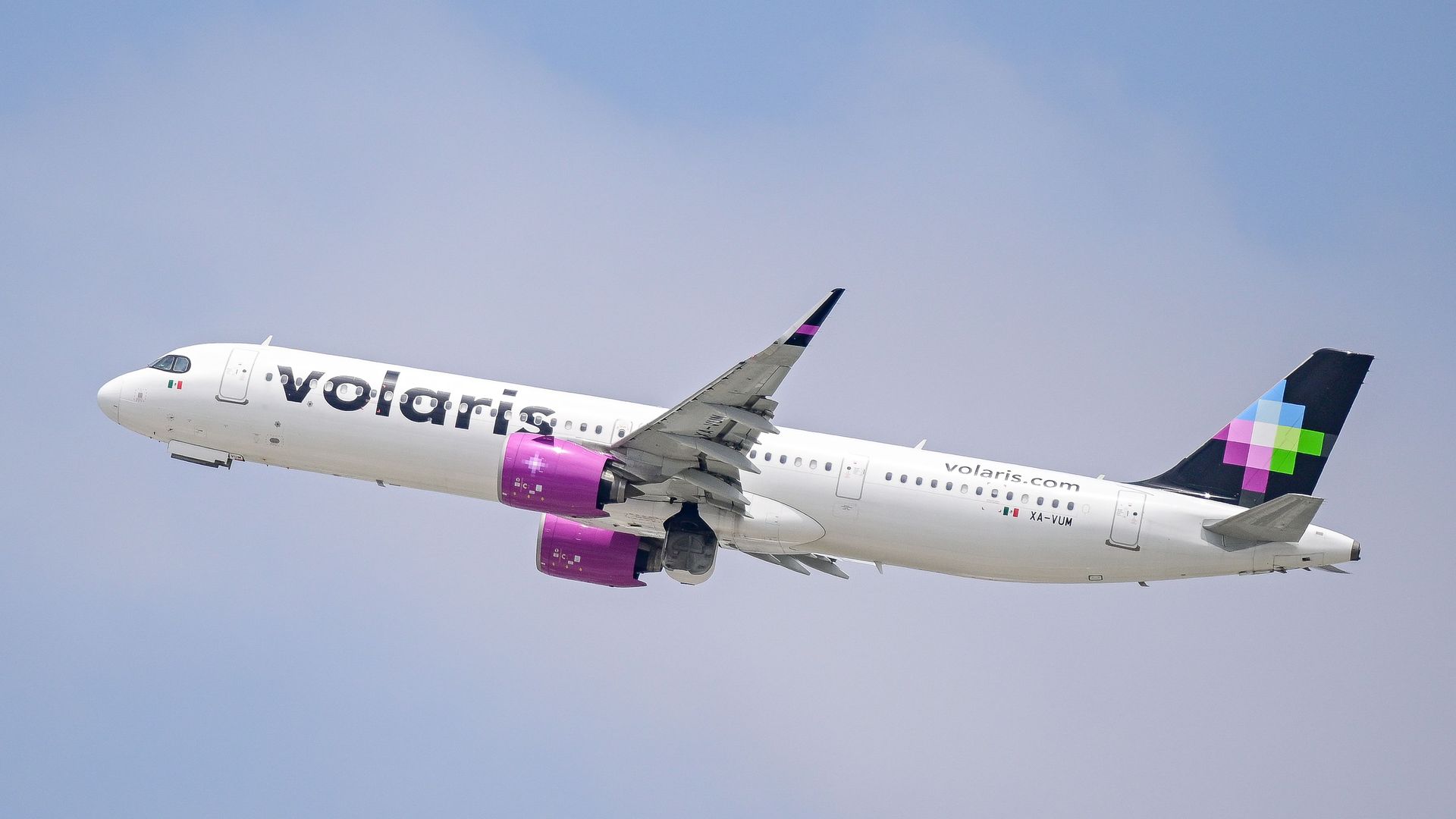A plane with Volaris signage in the air. 
