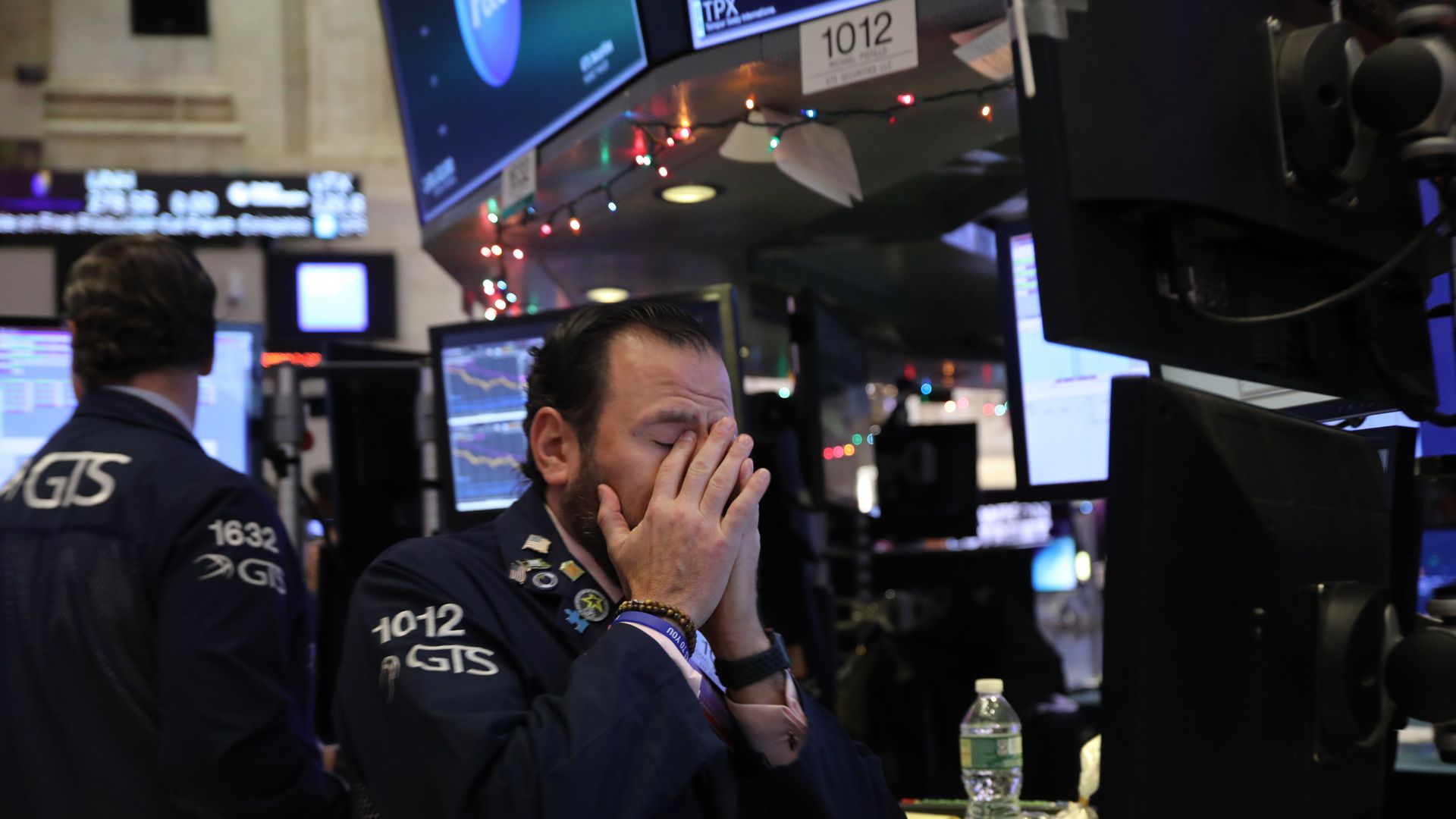 Stock trader with hands over his face.