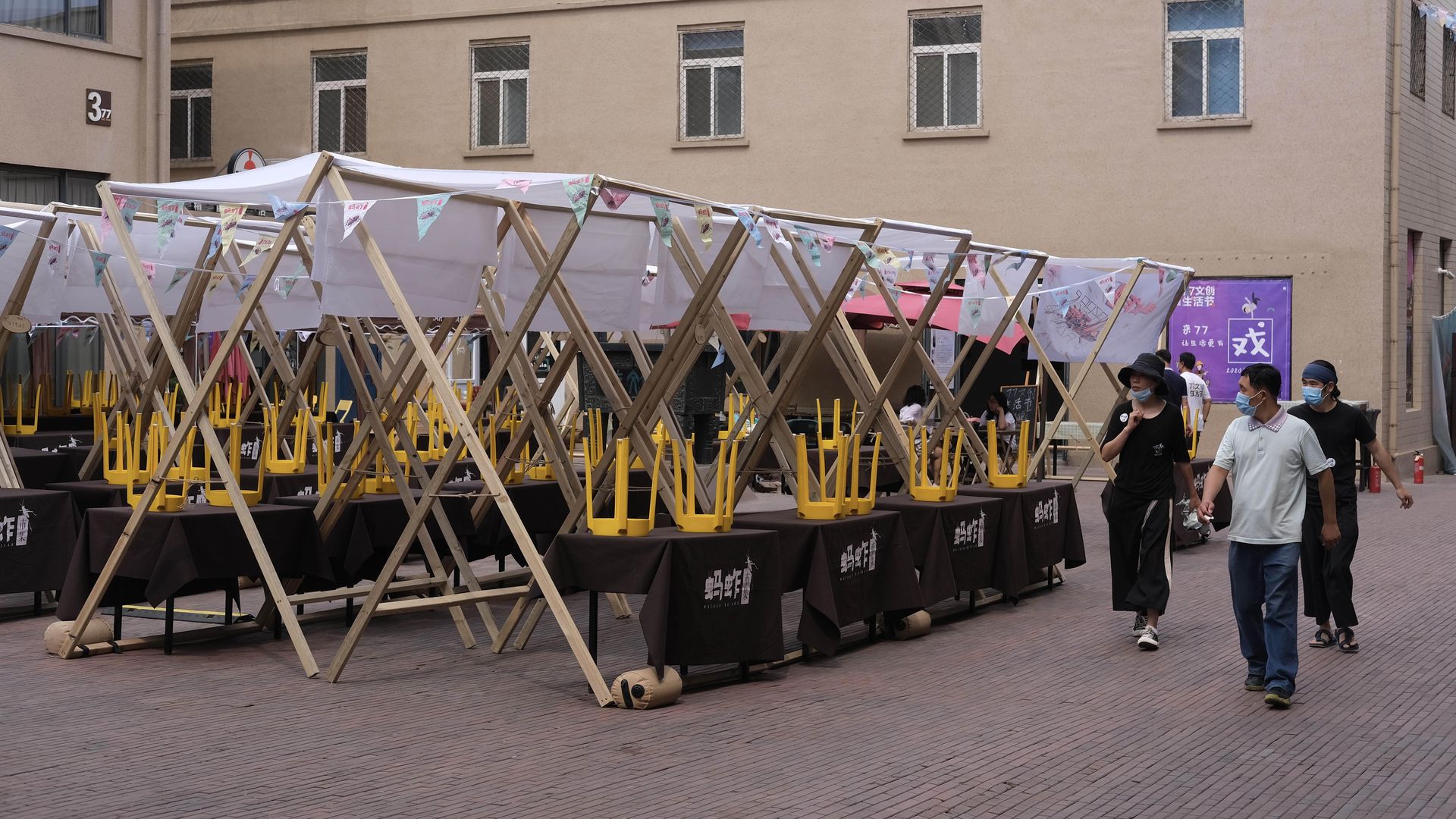 People walk by as a large market in closes in Beijing following a coronavirus outbreak